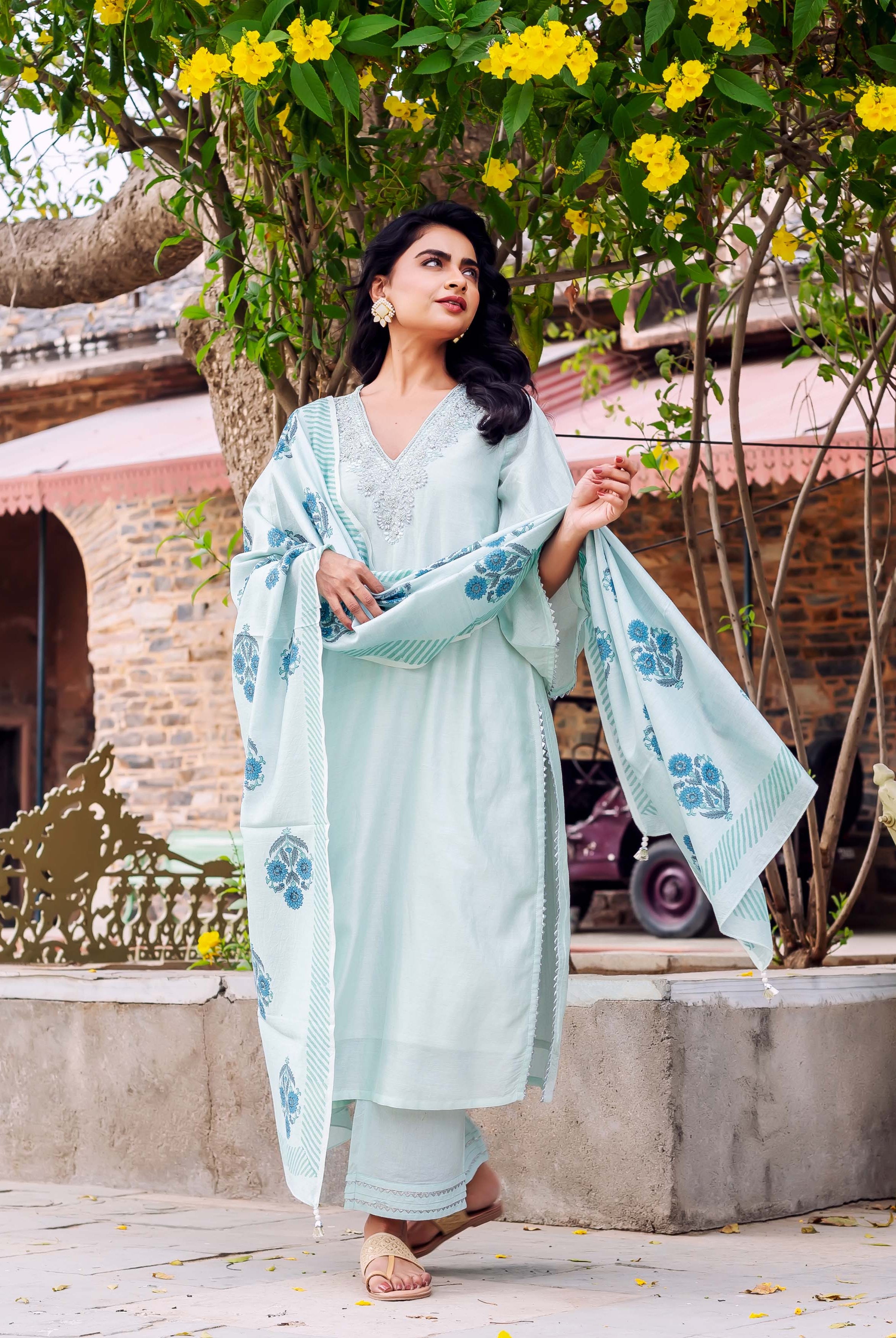 Woman models mint Chanderi silk kurta set with blue hand-block printed dupatta outdoors.