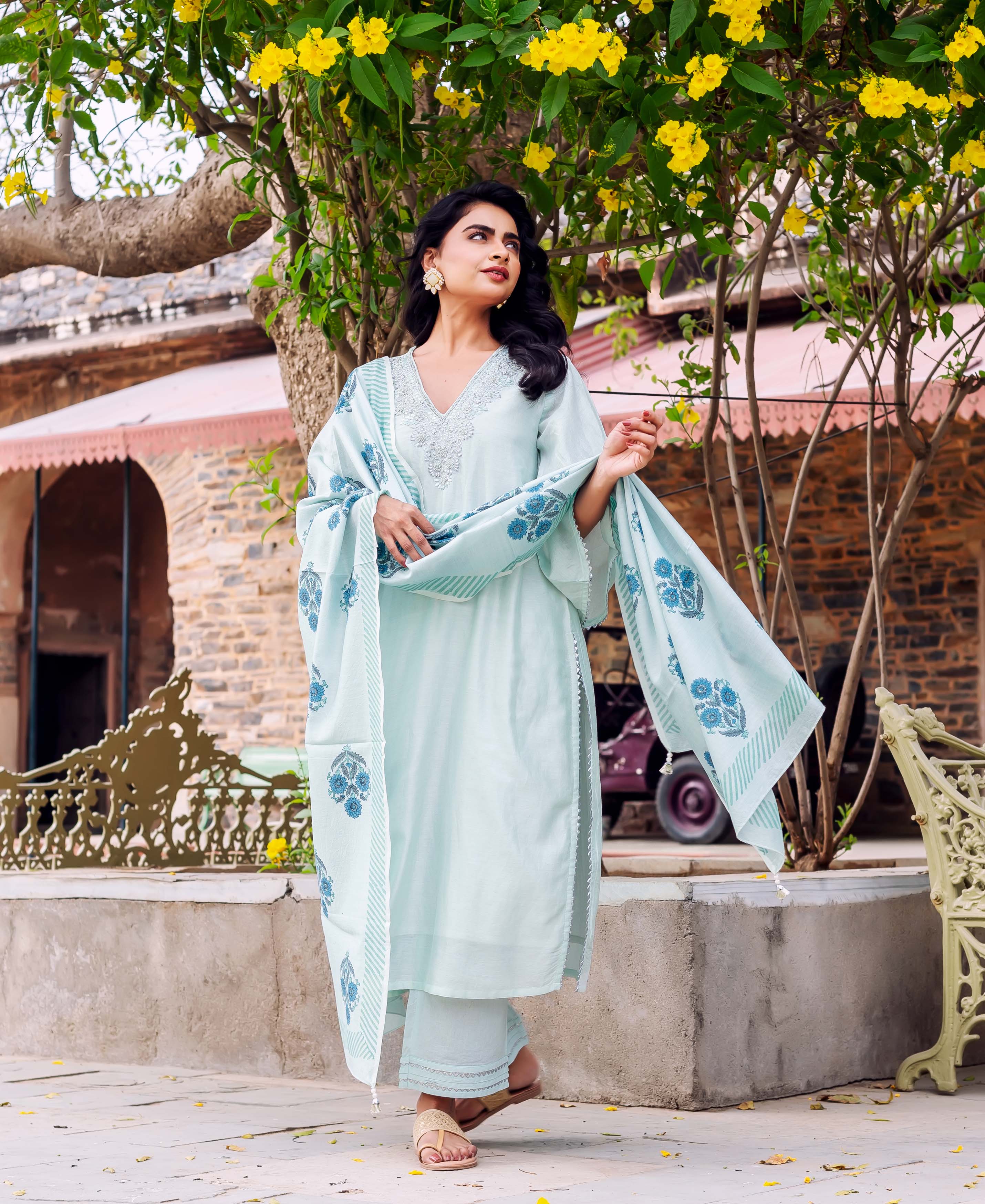 Woman models mint Chanderi silk kurta set with blue hand-block printed dupatta outdoors.