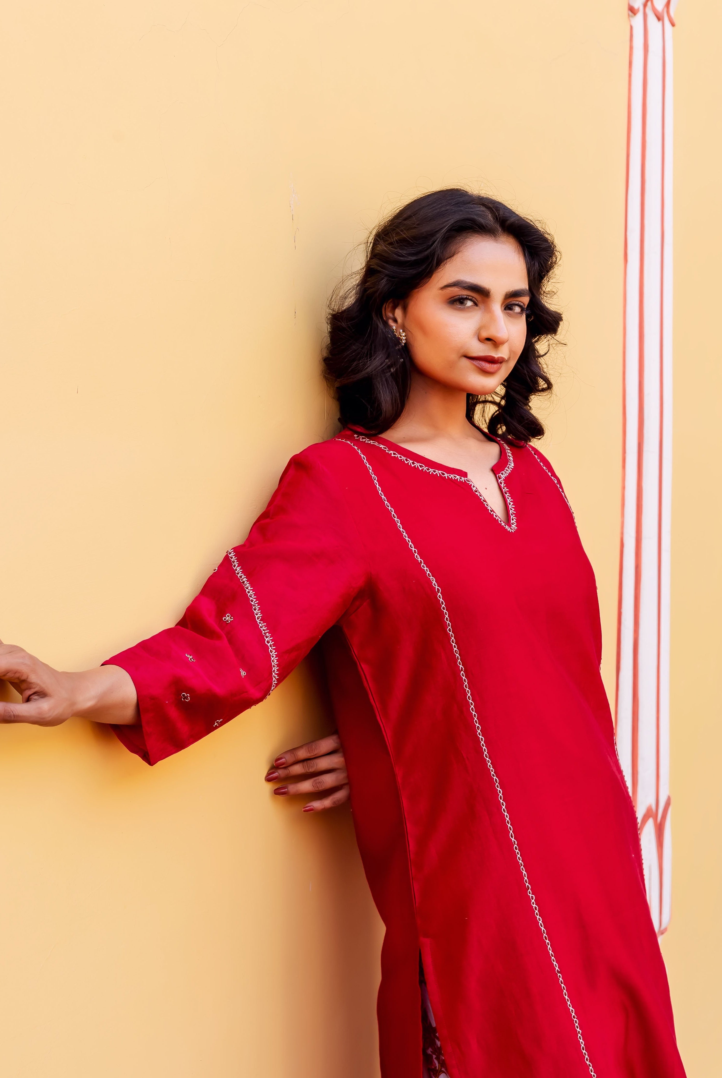 Woman models a bright red Chanderi kurta with delicate white embroidery.