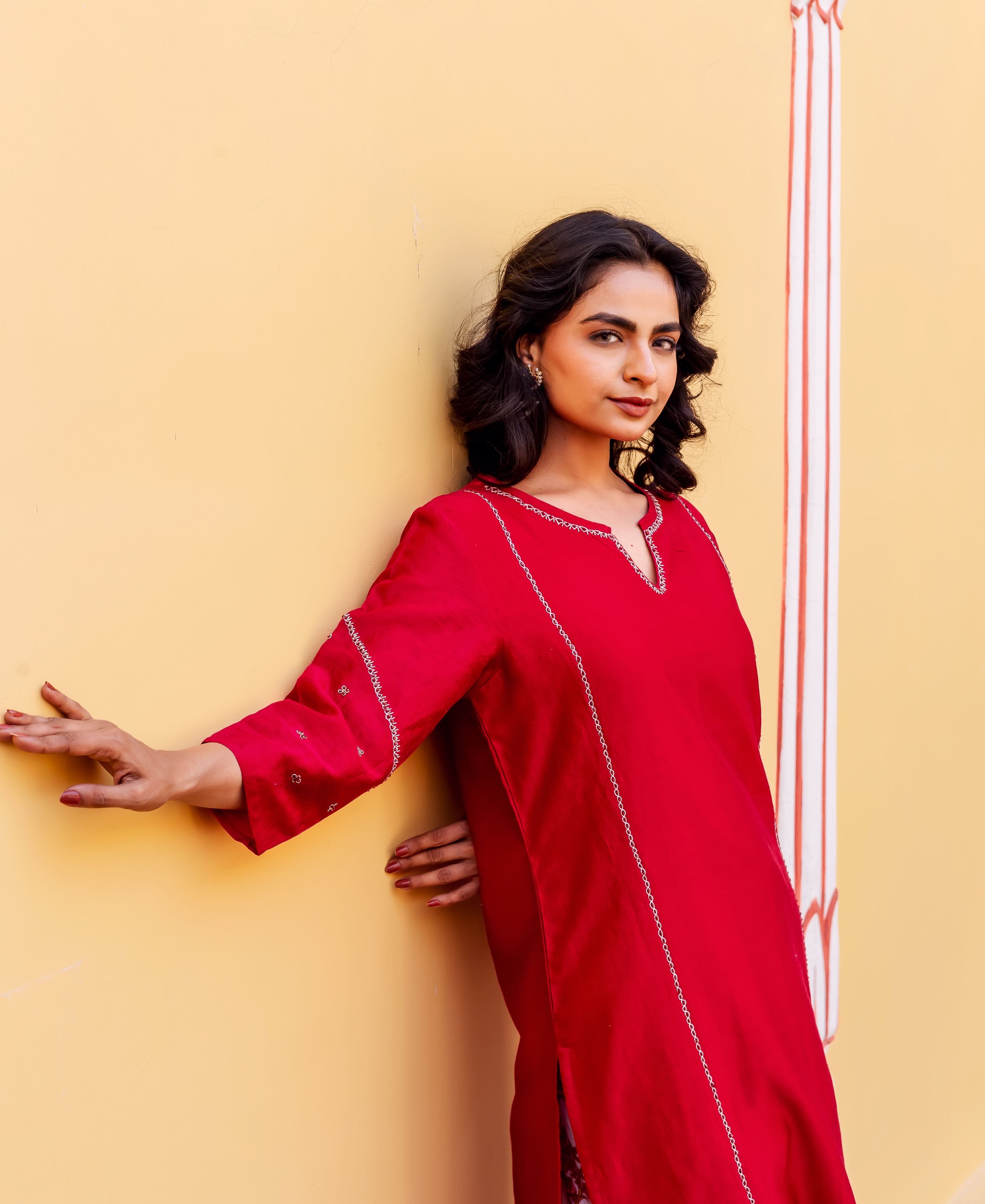 Woman models a bright red Chanderi kurta with delicate white embroidery.