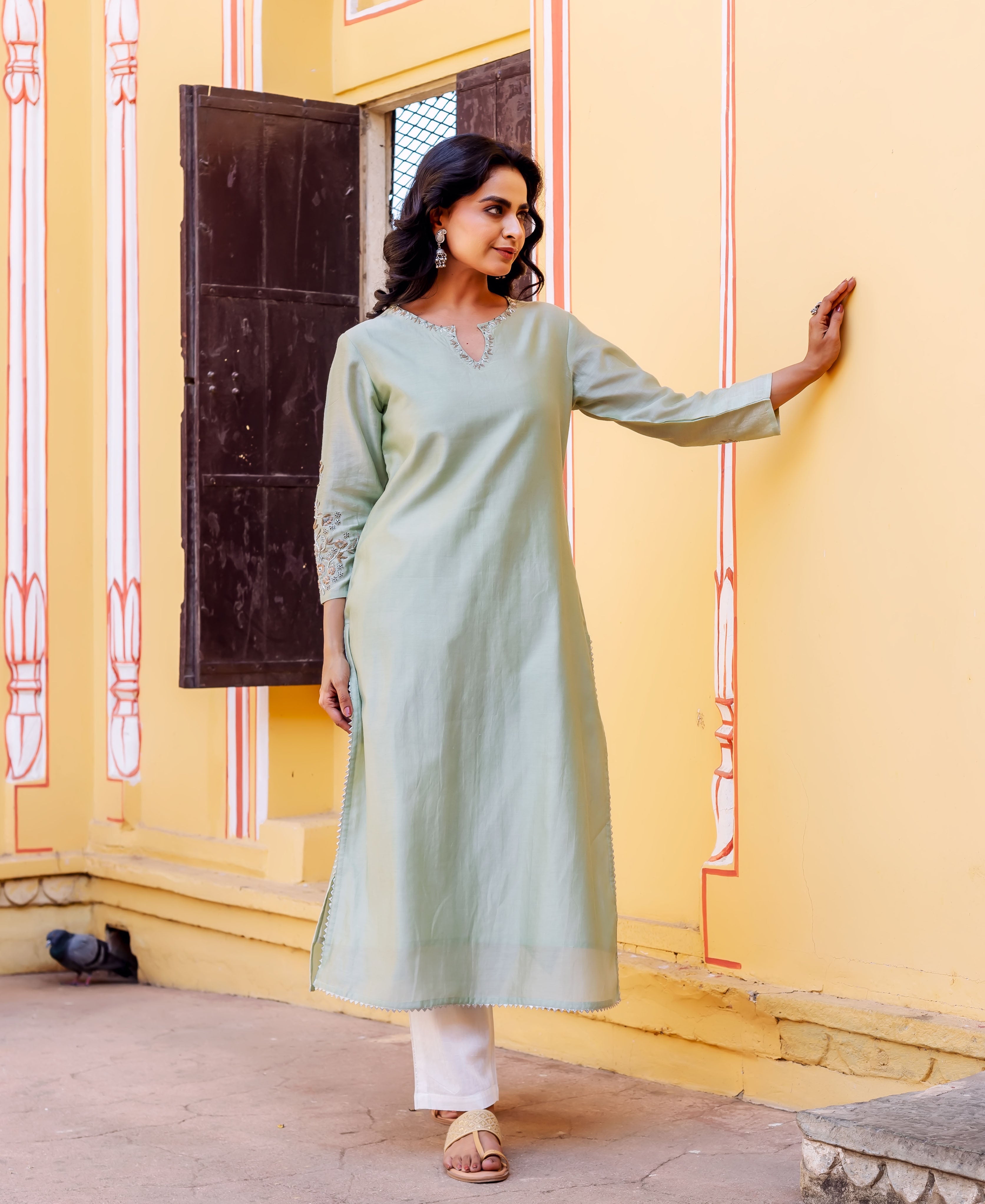 A model wearing a mint green kurta with block print on the sleeves.