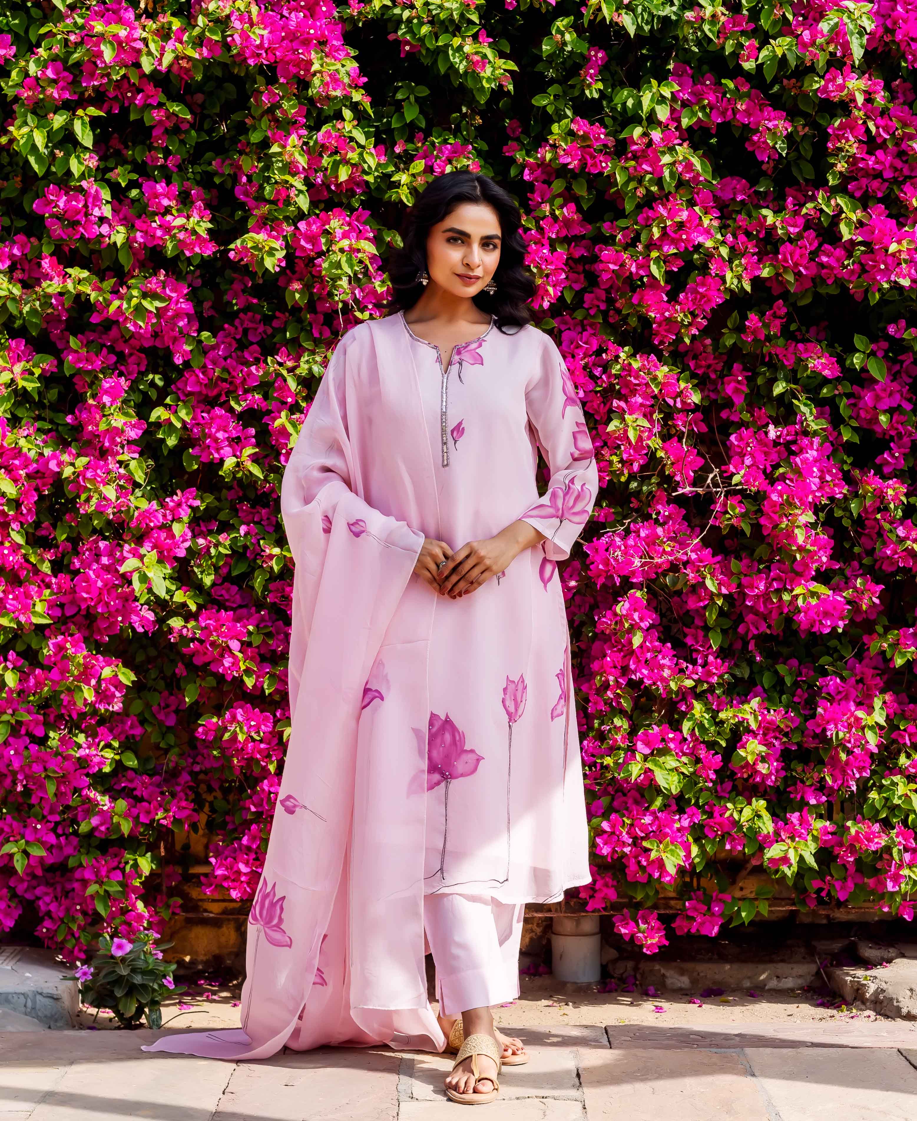 Front view of a woman in a pink organza kurta set with hand-block-printed lotus flowers.