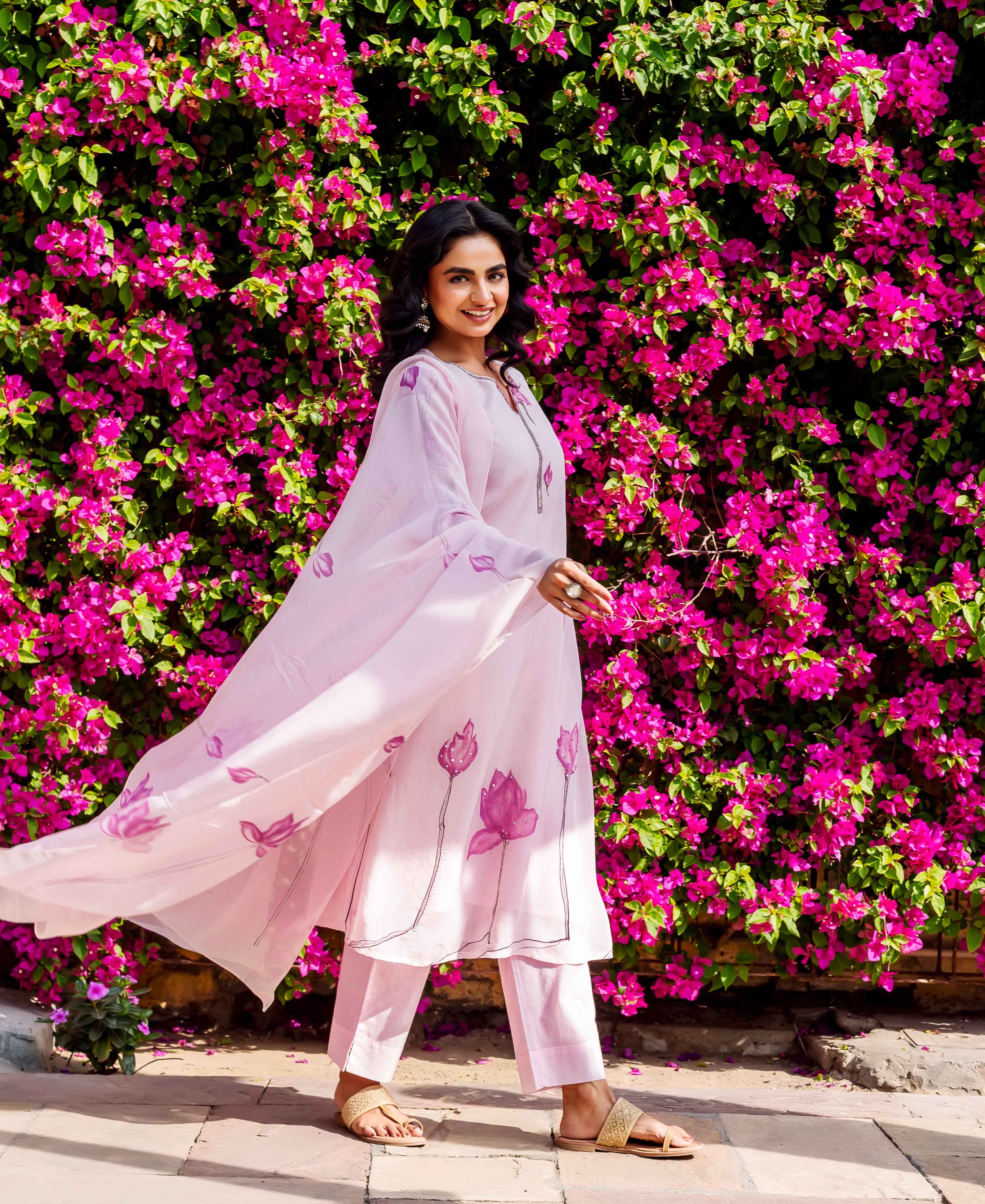 Smiling model in a light pink organza kurta set with block-printed lotus flowers.