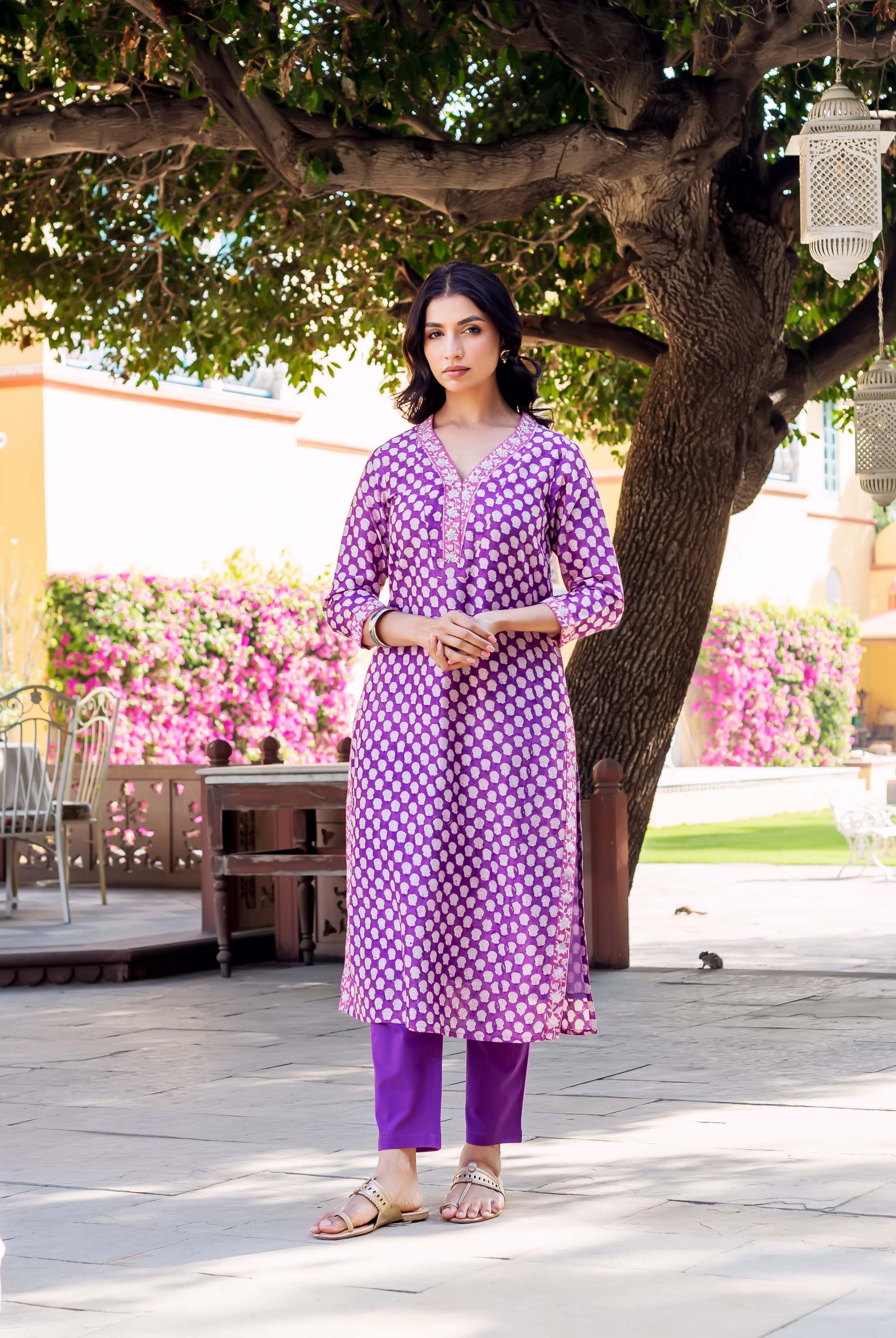 Front view of model in a full purple kurta set with white dot print.