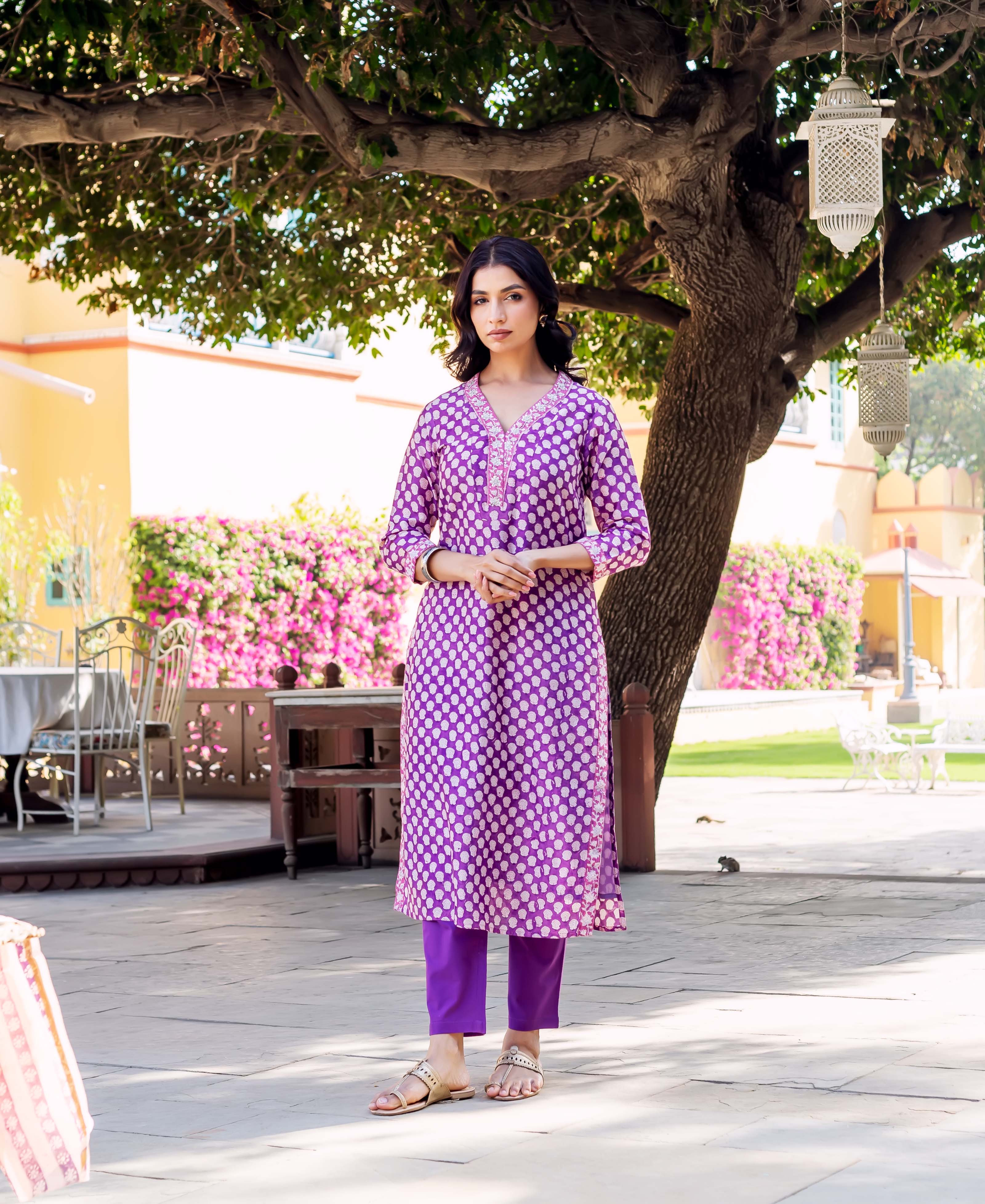 Front view of model in a full purple kurta set with white dot print.