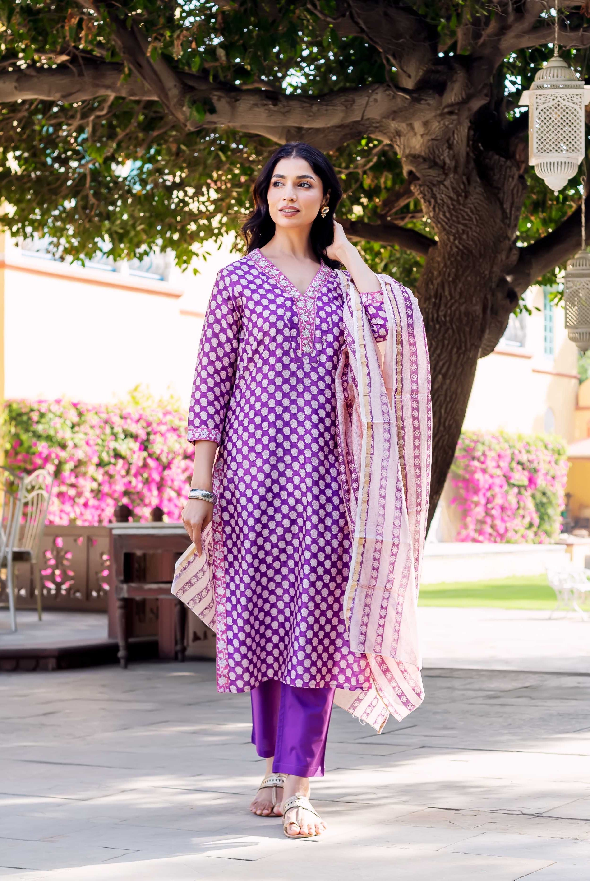 Woman wearing purple chanderi kurta with white polka dots and matching pants.