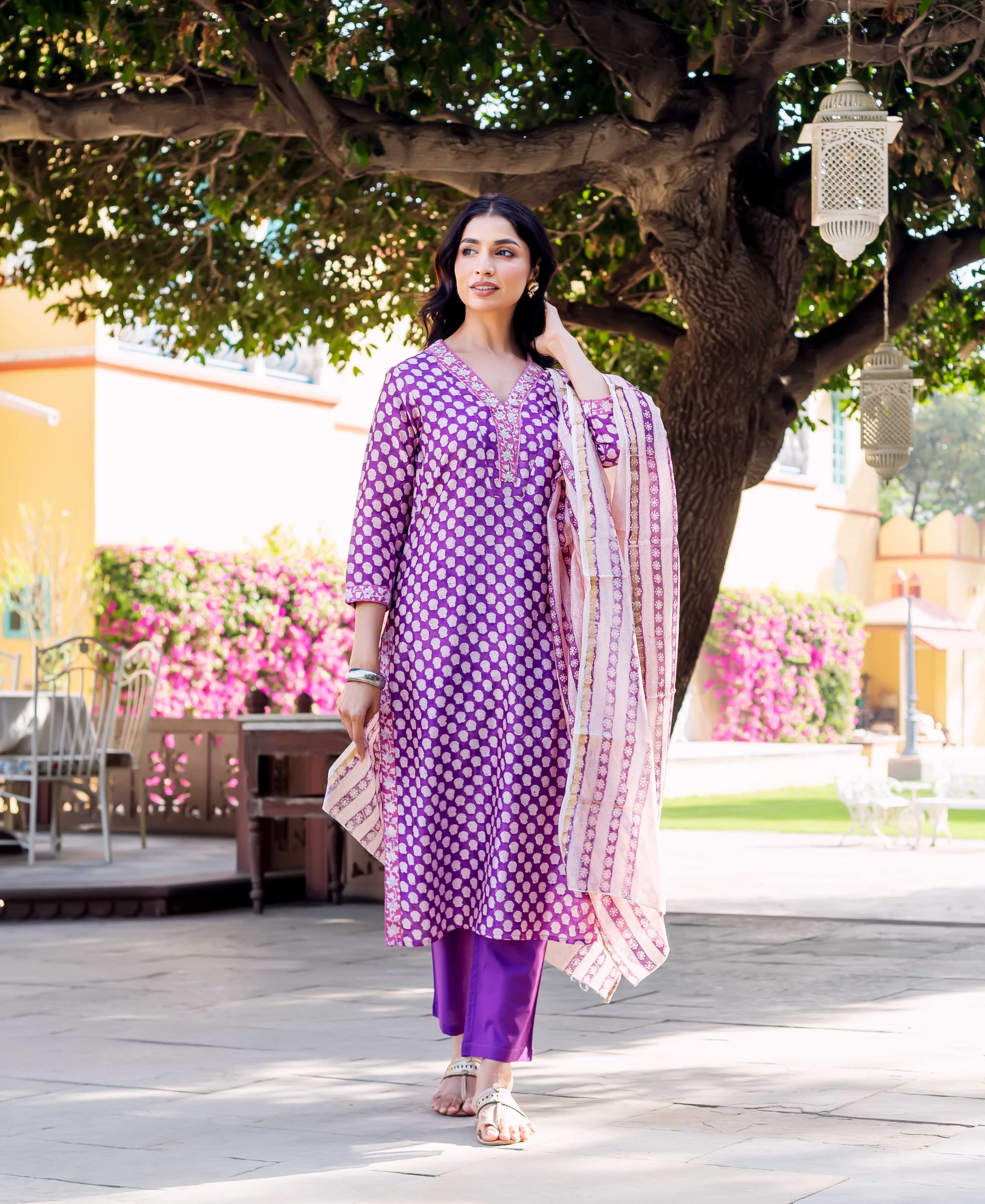 Woman wearing purple chanderi kurta with white polka dots and matching pants.