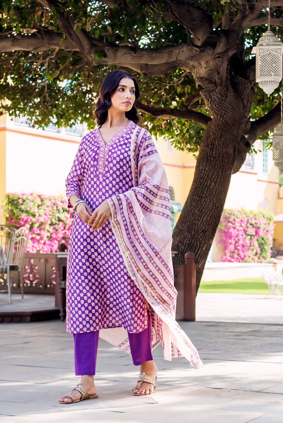 Model in purple hand-block-printed kurta with white dot print, matching pants, and light striped dupatta.