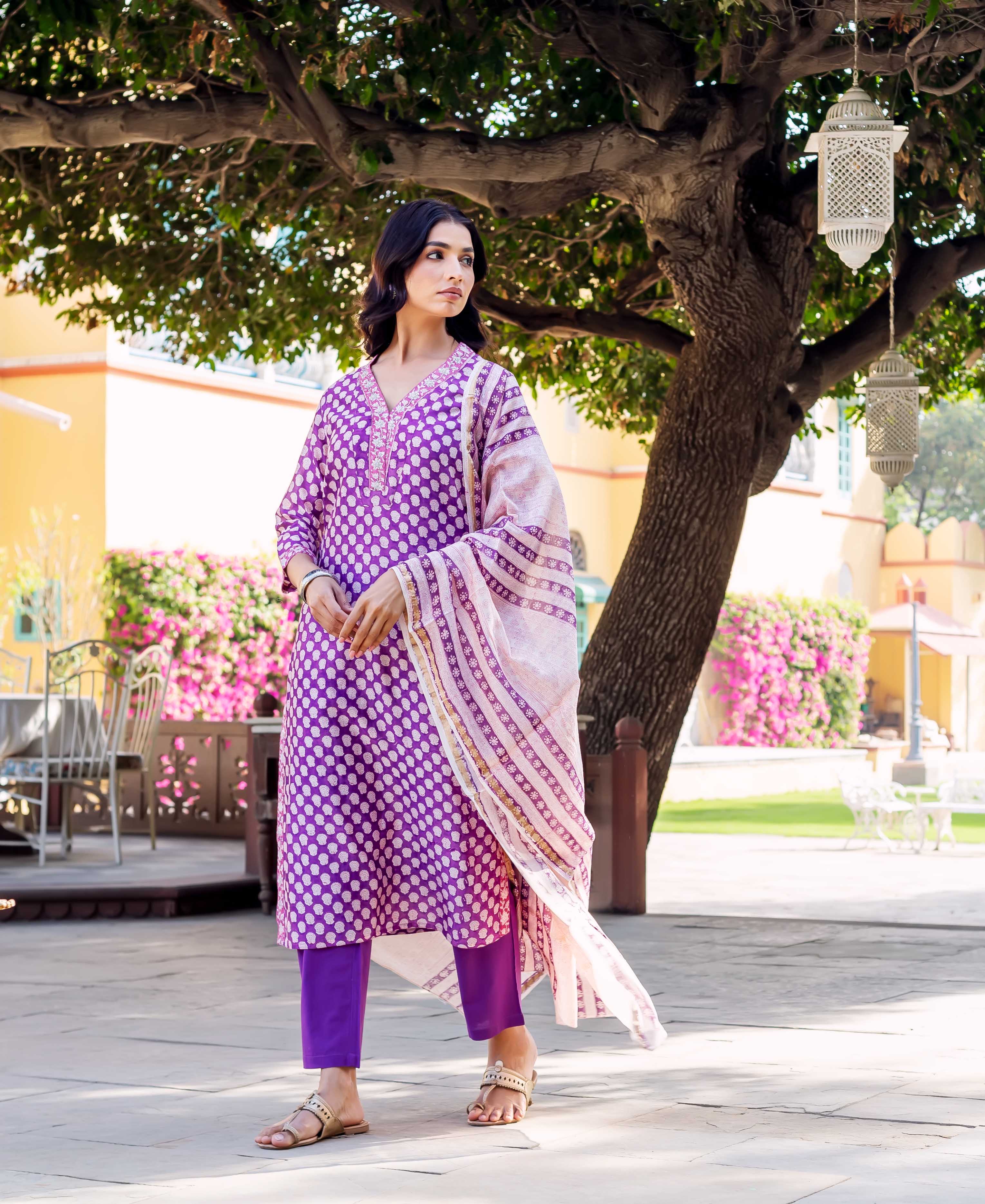 Model in purple hand-block-printed kurta with white dot print, matching pants, and light striped dupatta.