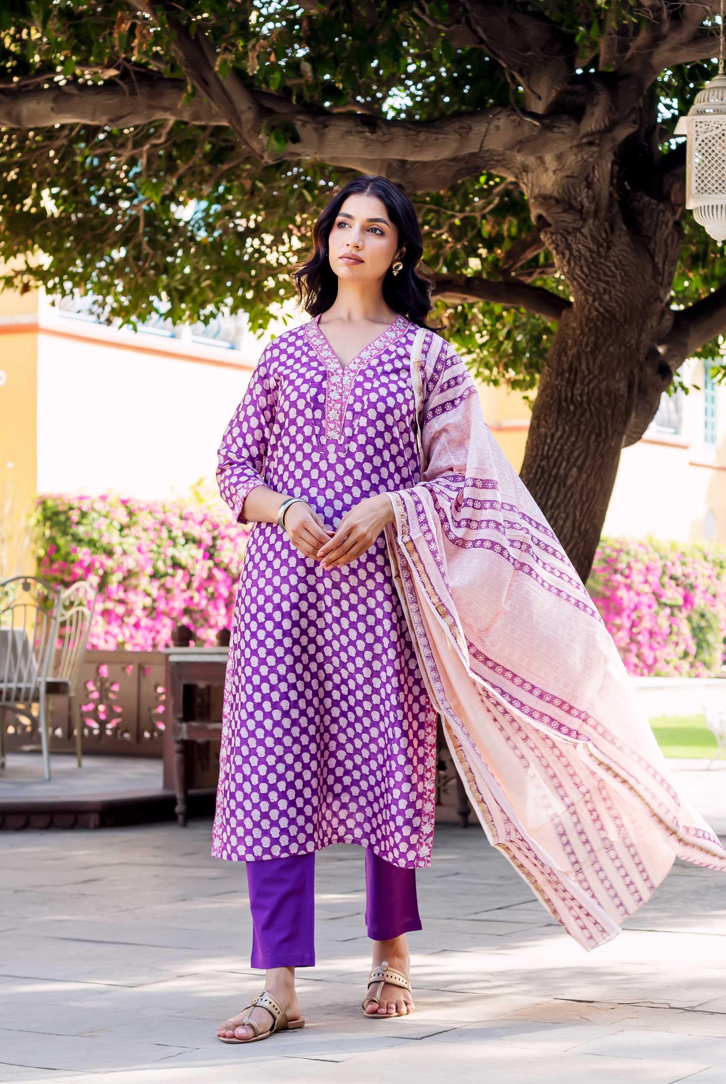 Front full look of model in purple block-printed kurta set with light pink dupatta.