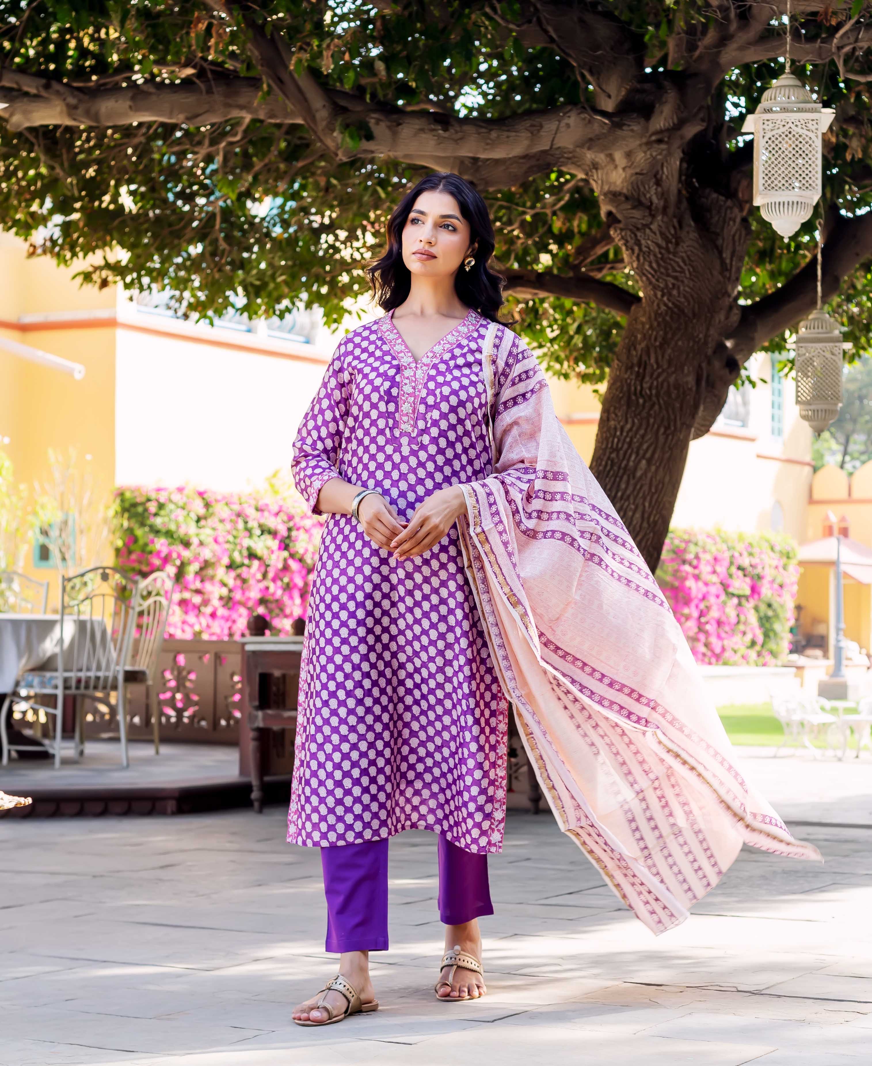 Front full look of model in purple block-printed kurta set with light pink dupatta.
