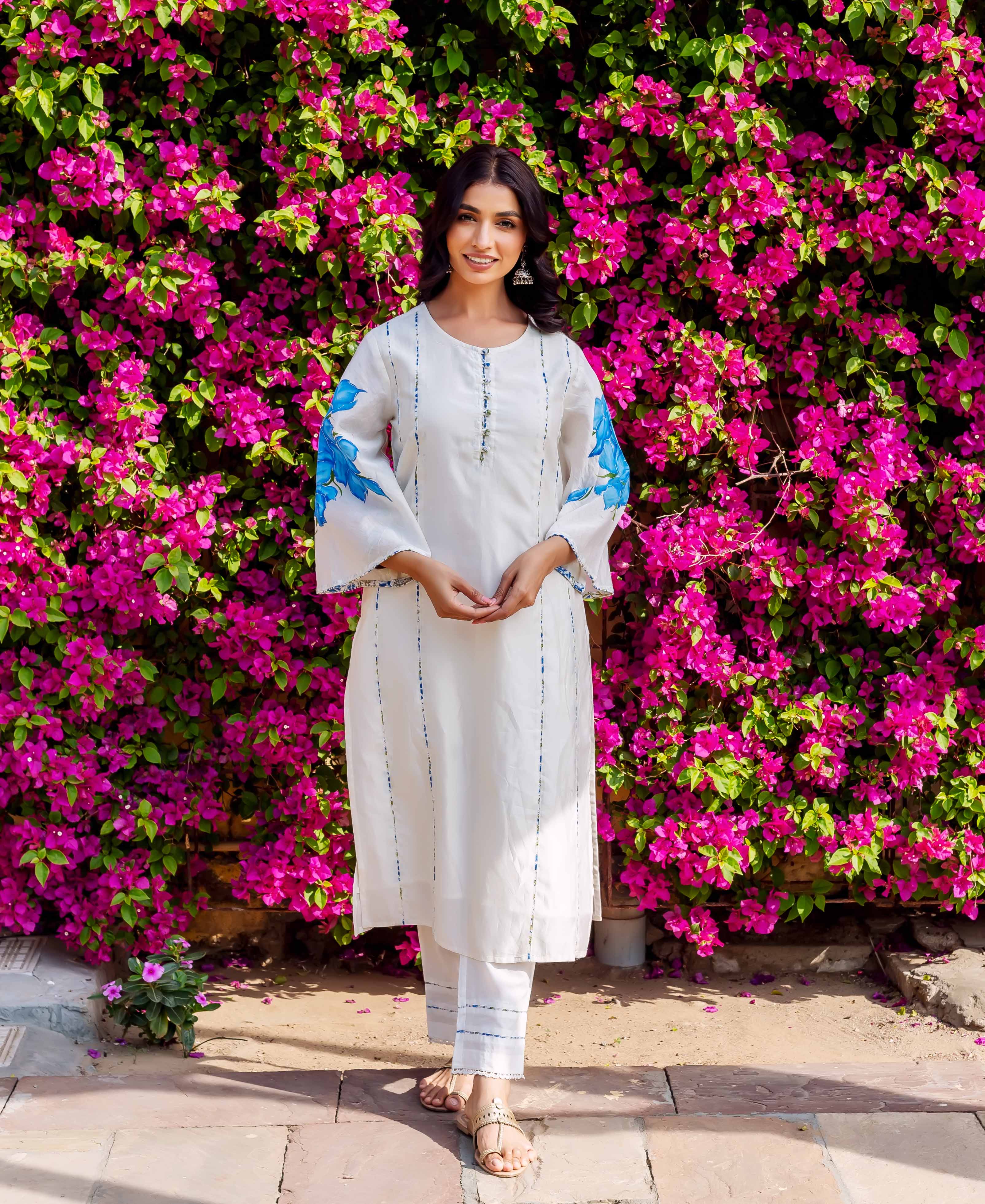 Front view of a model in a white kurta set with blue brush-painted floral sleeves and stripes.