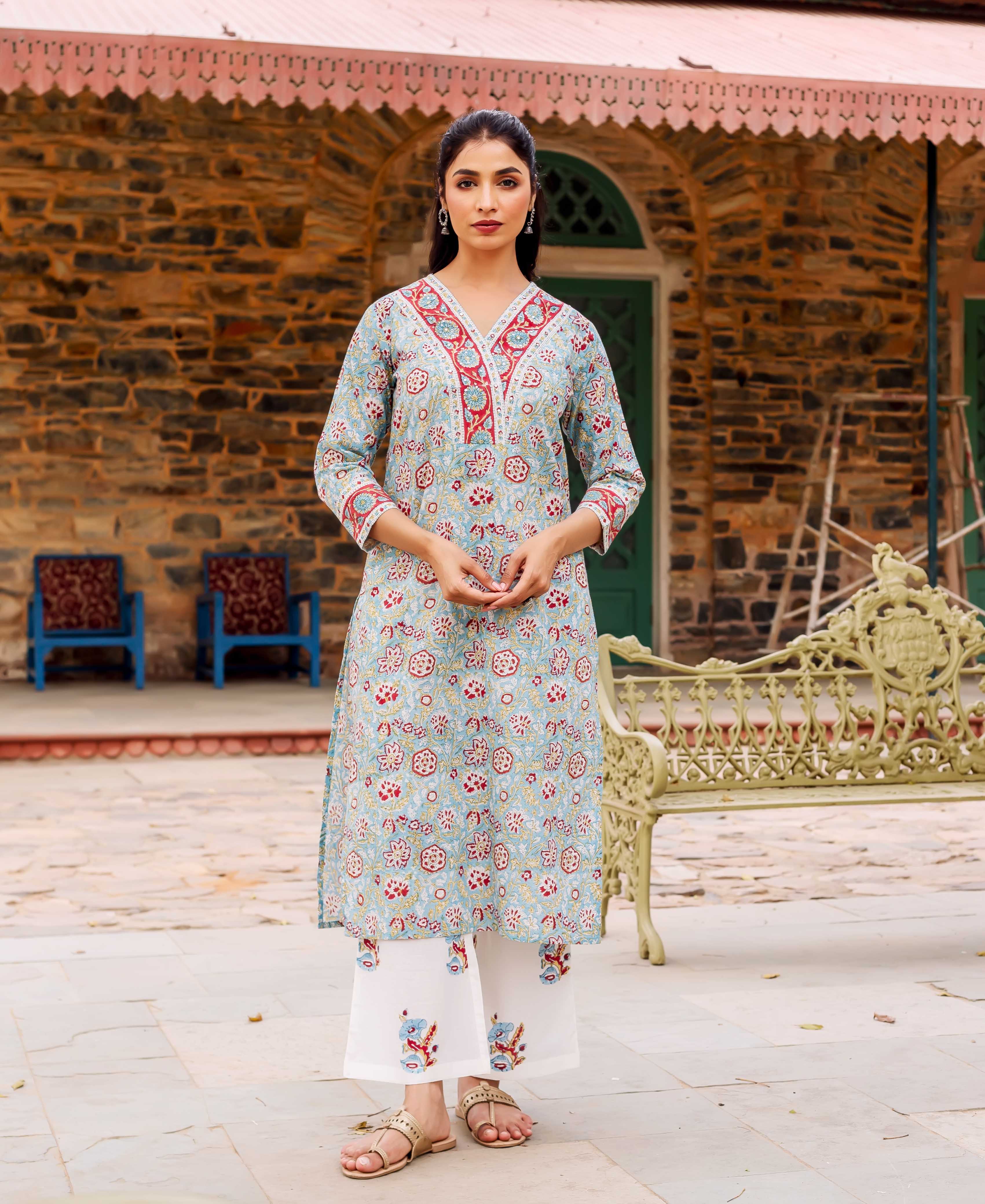 A model wearing a teal cotton kurta with red and white floral print.