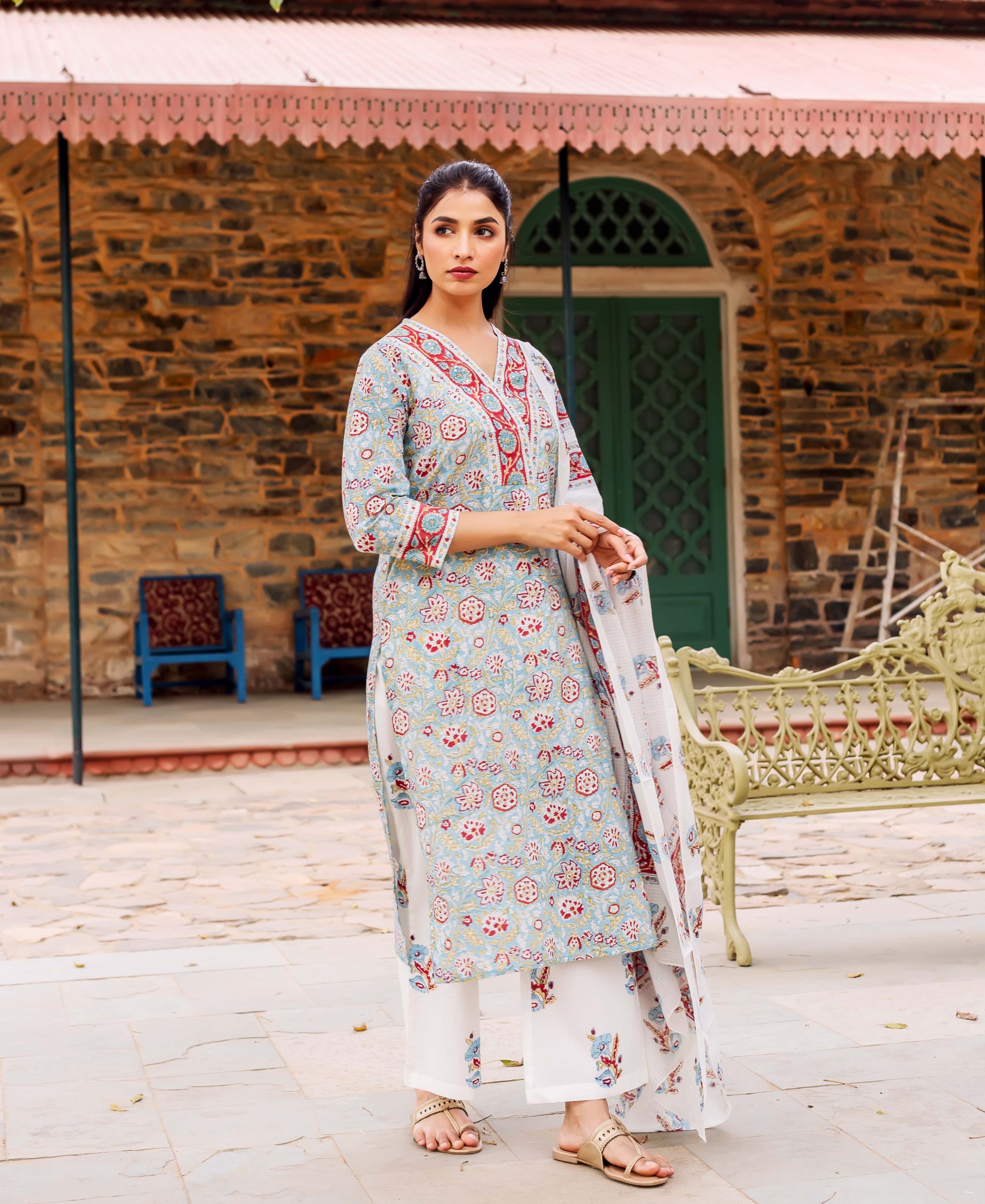 Model in a teal hand-block printed cotton kurta set with red and blue floral design.