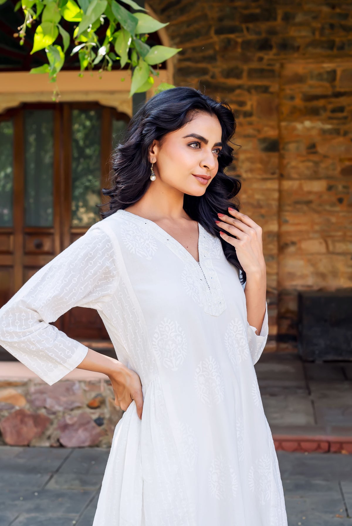 Model in a white cotton kurta, featuring a V-neck and subtle hand-block printed motifs.
