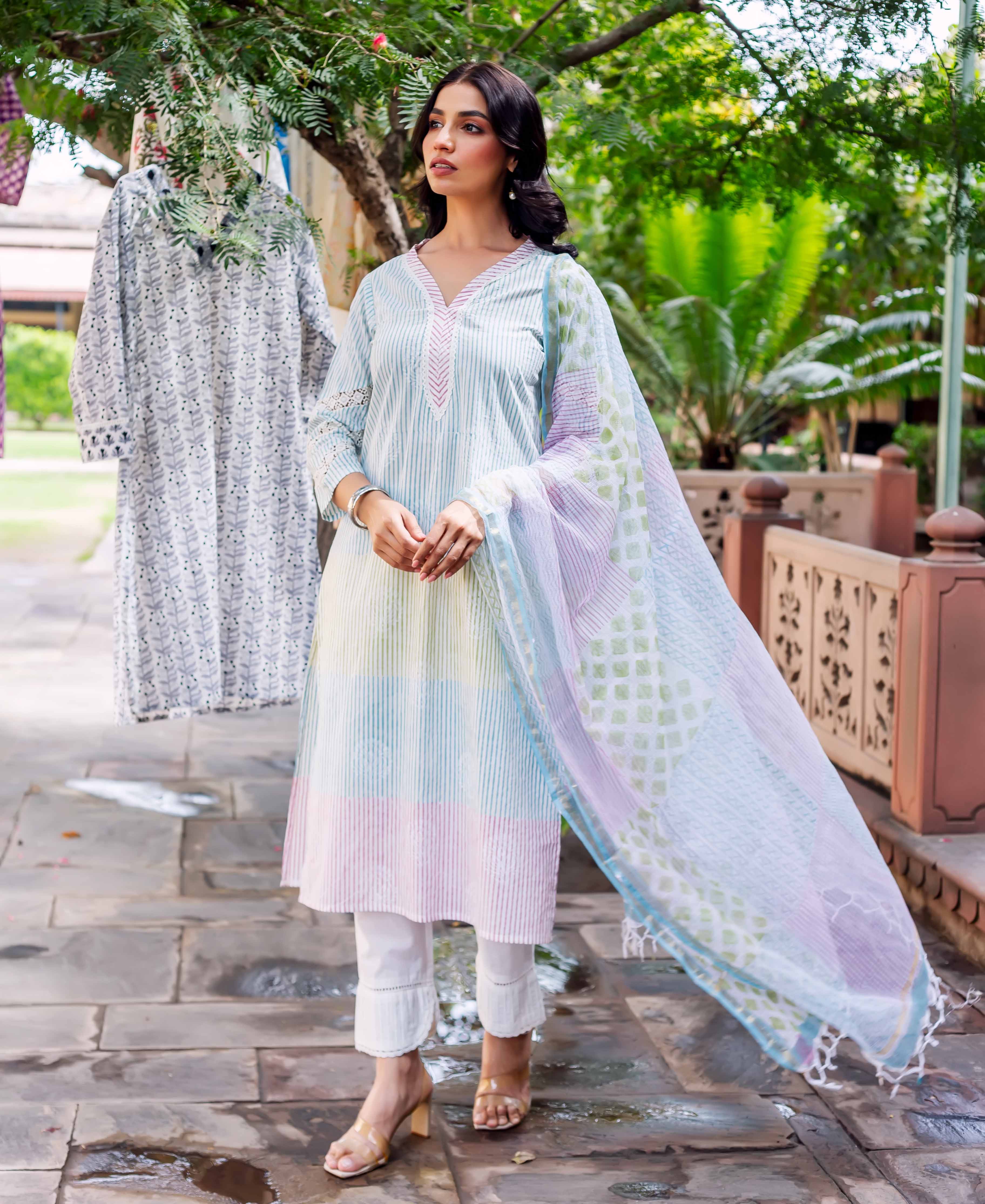 Front view of model in full pastel striped kurta, white pants, and sheer printed dupatta.