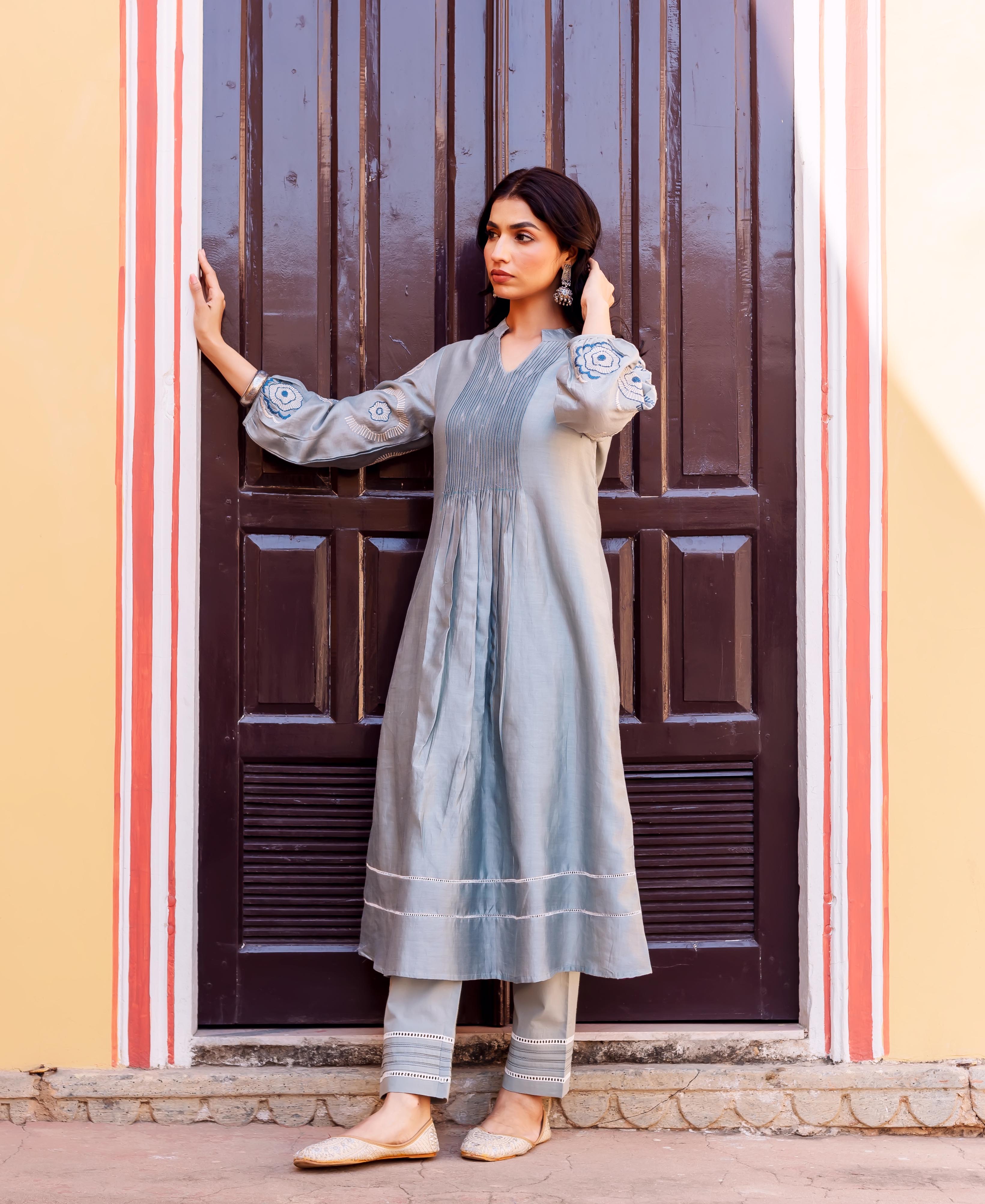 Model in slate blue chanderi kurta set with pintucks and blue hand-block printed sleeves.