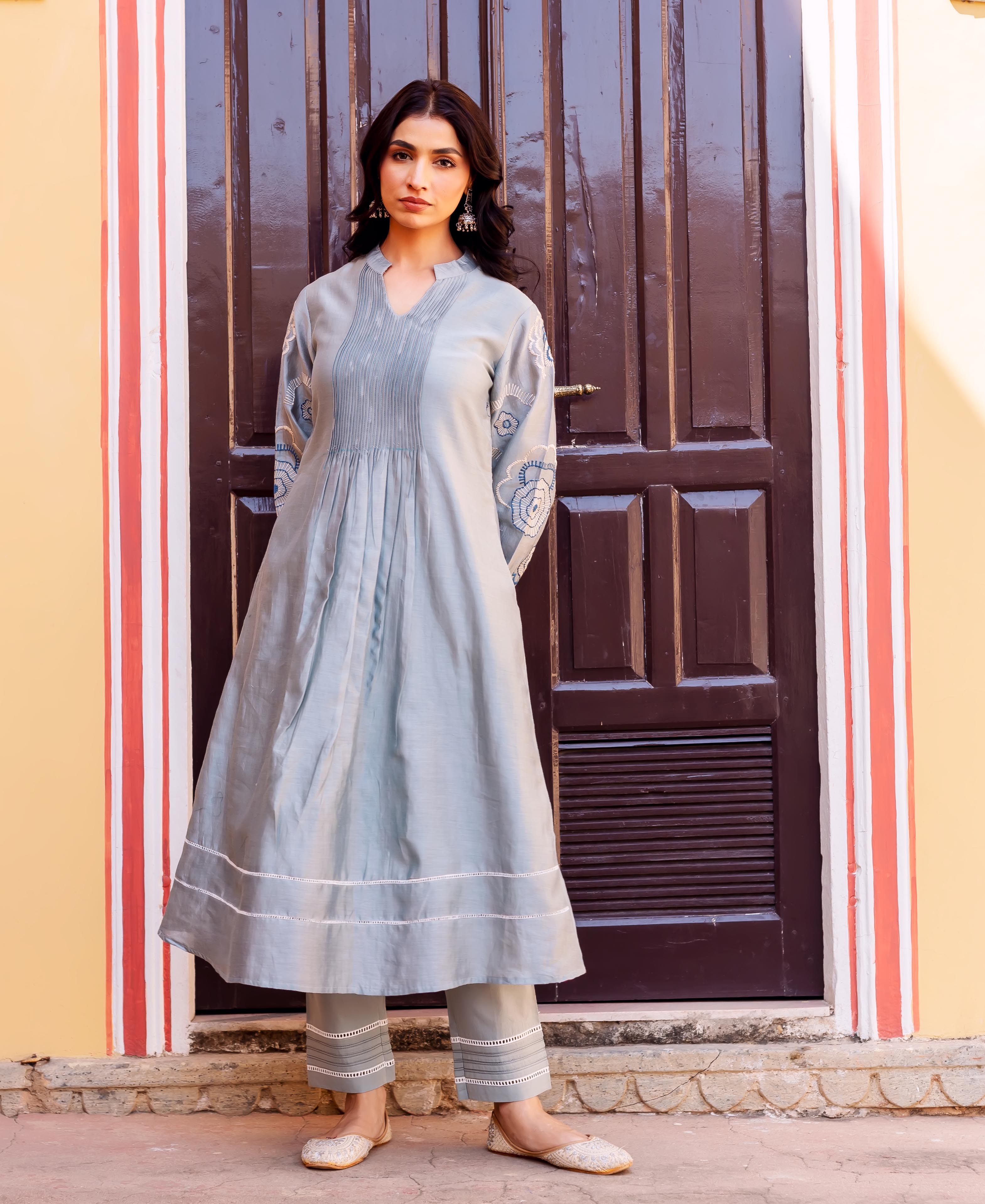 Full length view of woman in slate blue Chanderi silk kurta and pants with white embroidery.