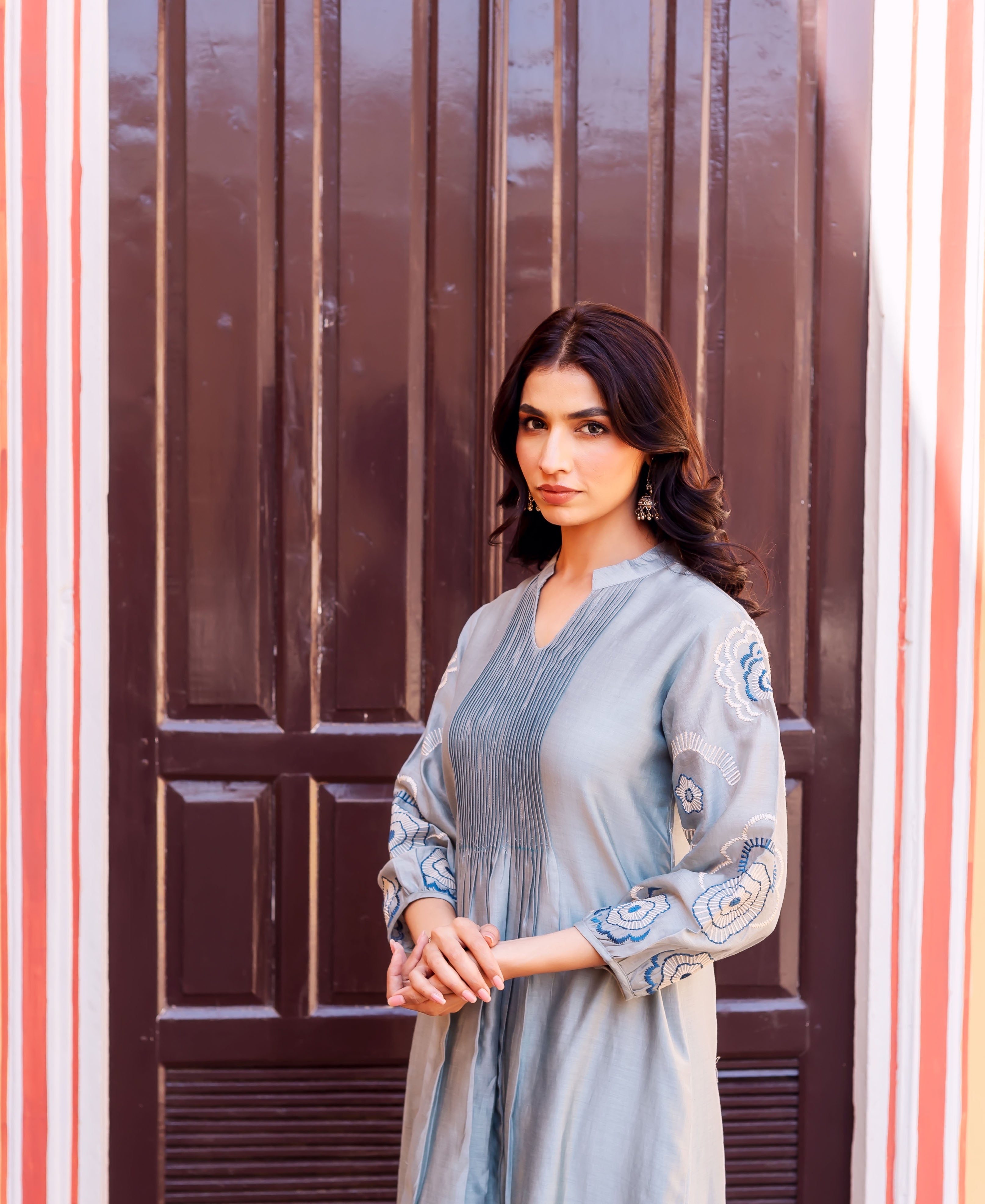 Model wearing a slate blue Chanderi silk kurta with pleated yoke and floral hand-block prints.