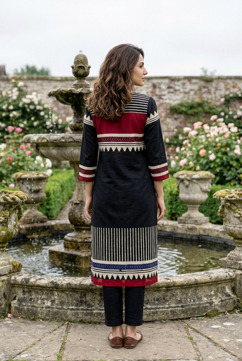 Model's back in black cotton kurta with maroon and white tribal block prints, blue accent.