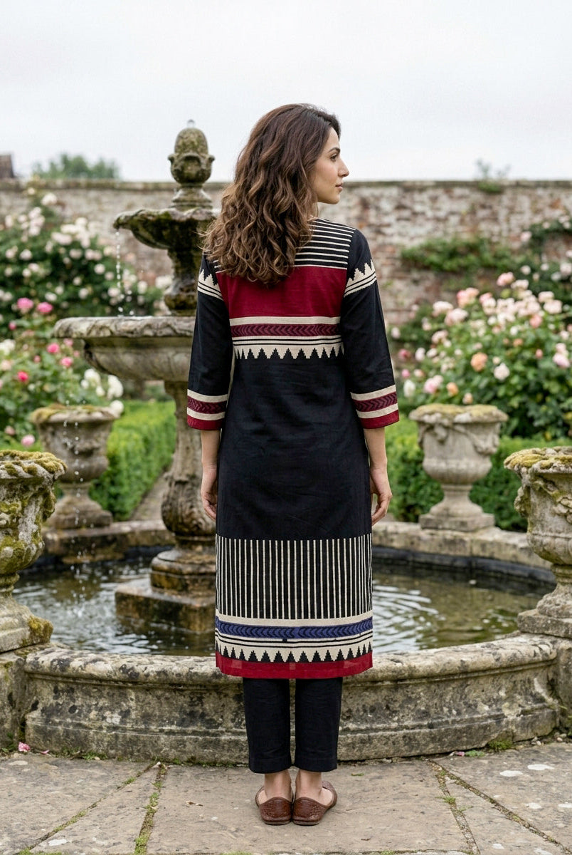 Model's back in black cotton kurta with maroon and white tribal block prints, blue accent.