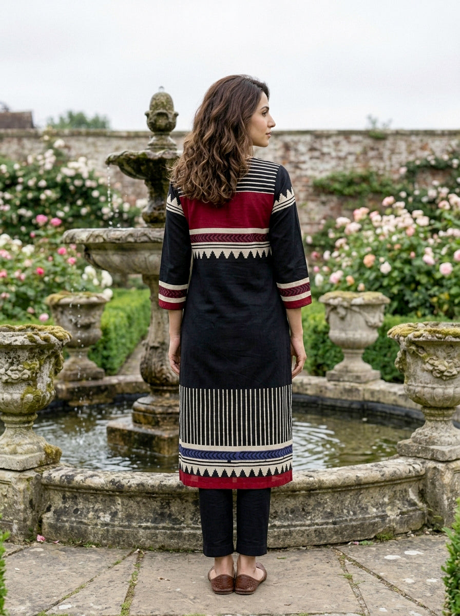 Model's back in black cotton kurta with maroon and white tribal block prints, blue accent.