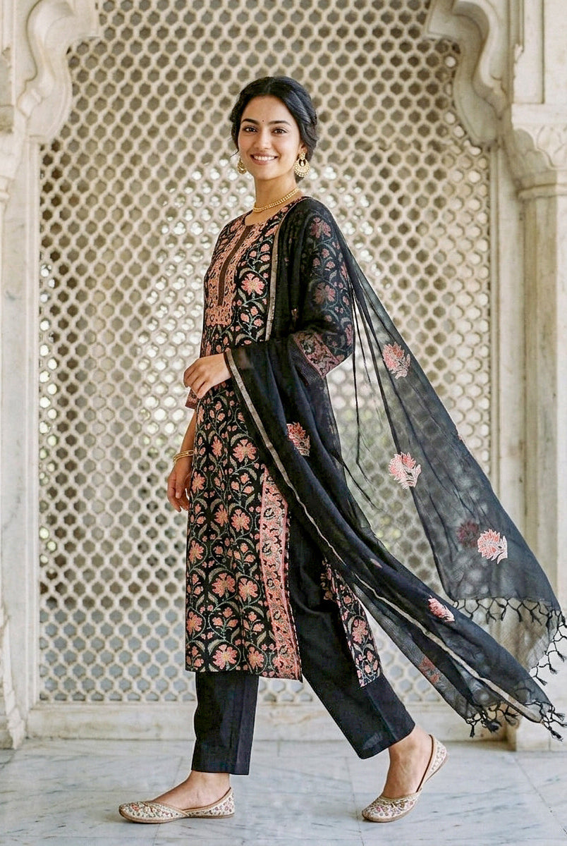 Side-angle model wears black floral hand block print kurta set with matching dupatta.