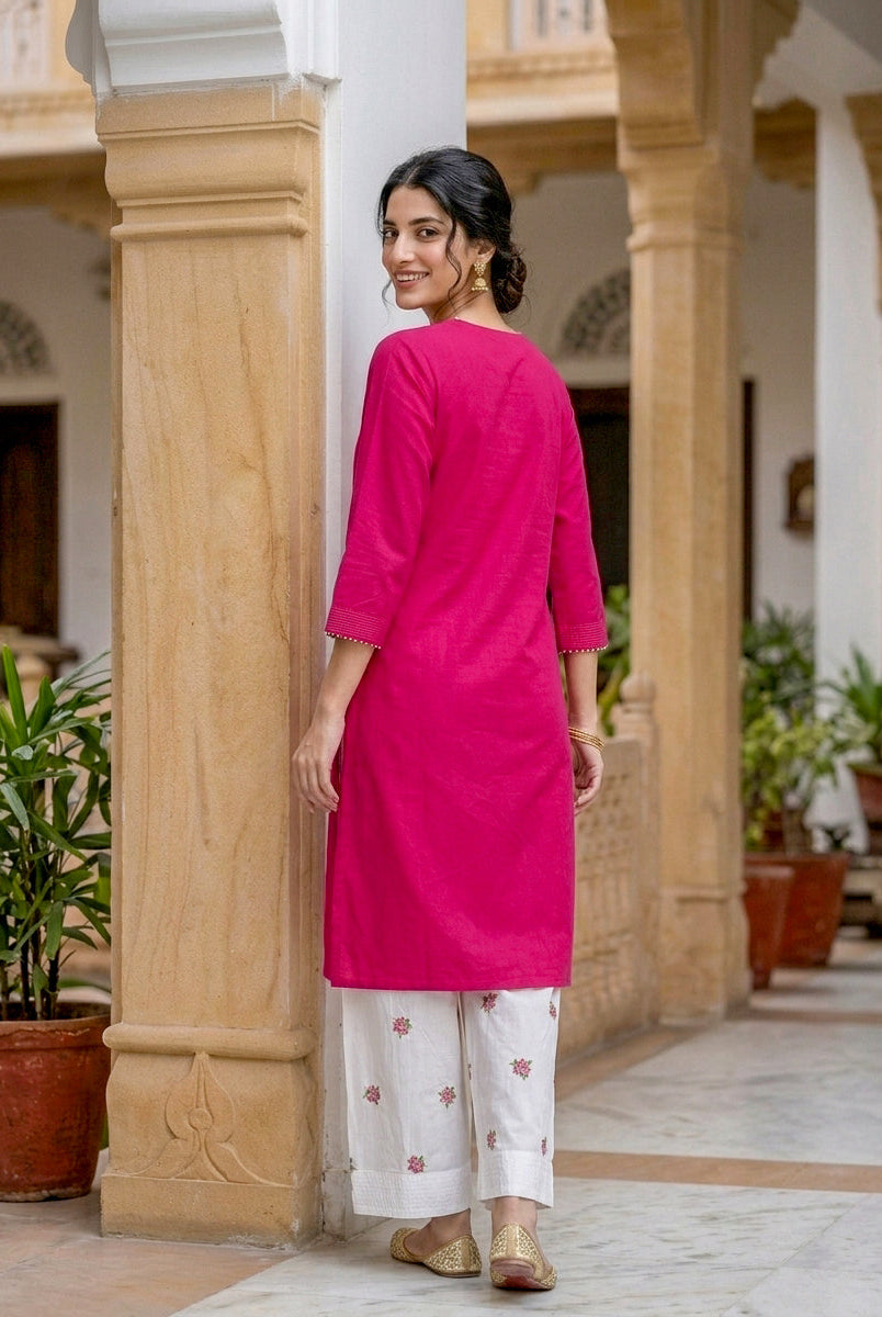 Back view of model in fuchsia pink kurta and white floral embroidered bottoms.