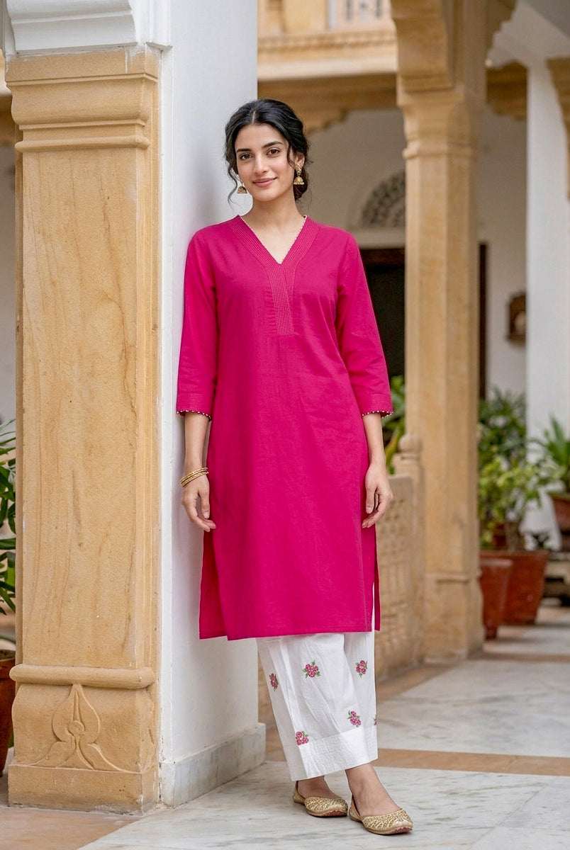 Model wearing fuchsia pink kurta with white salwar featuring pink floral embroidery.