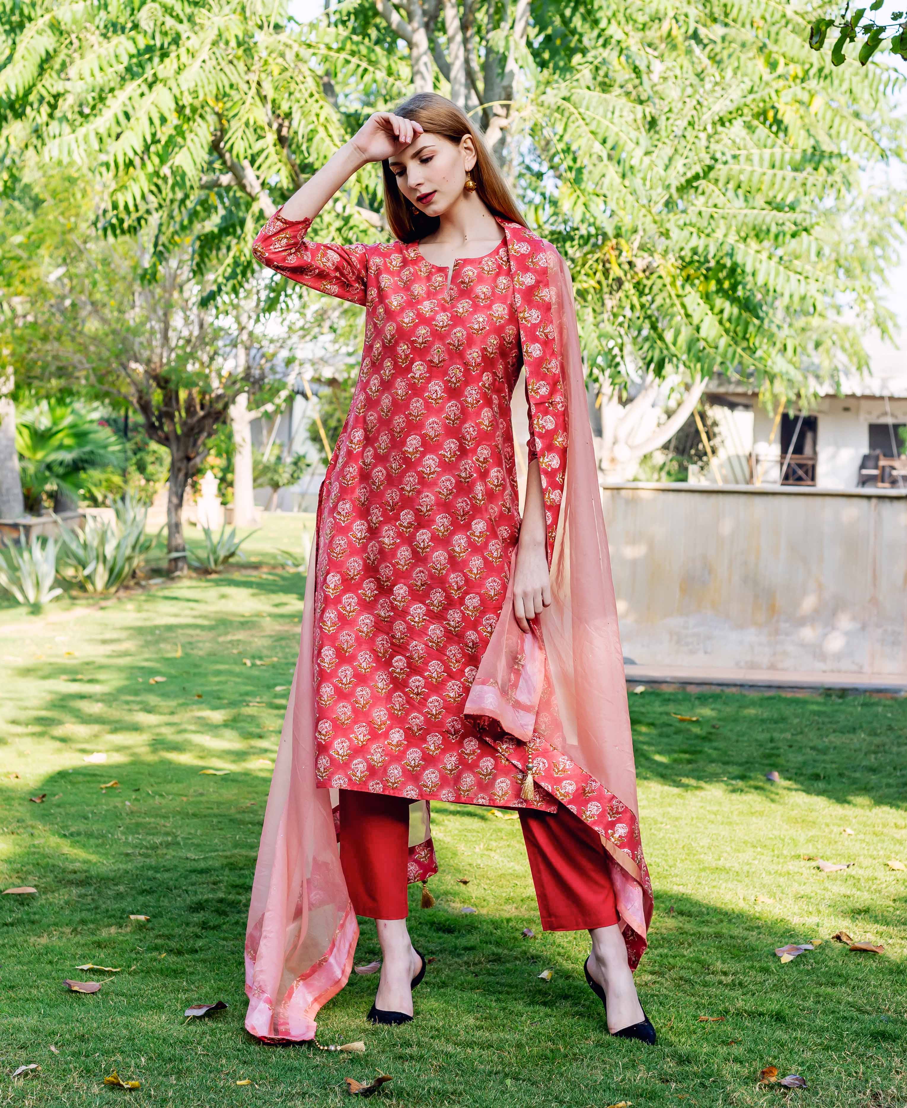 Full shot of model in red hand-block printed floral straight kurta set with dupatta.