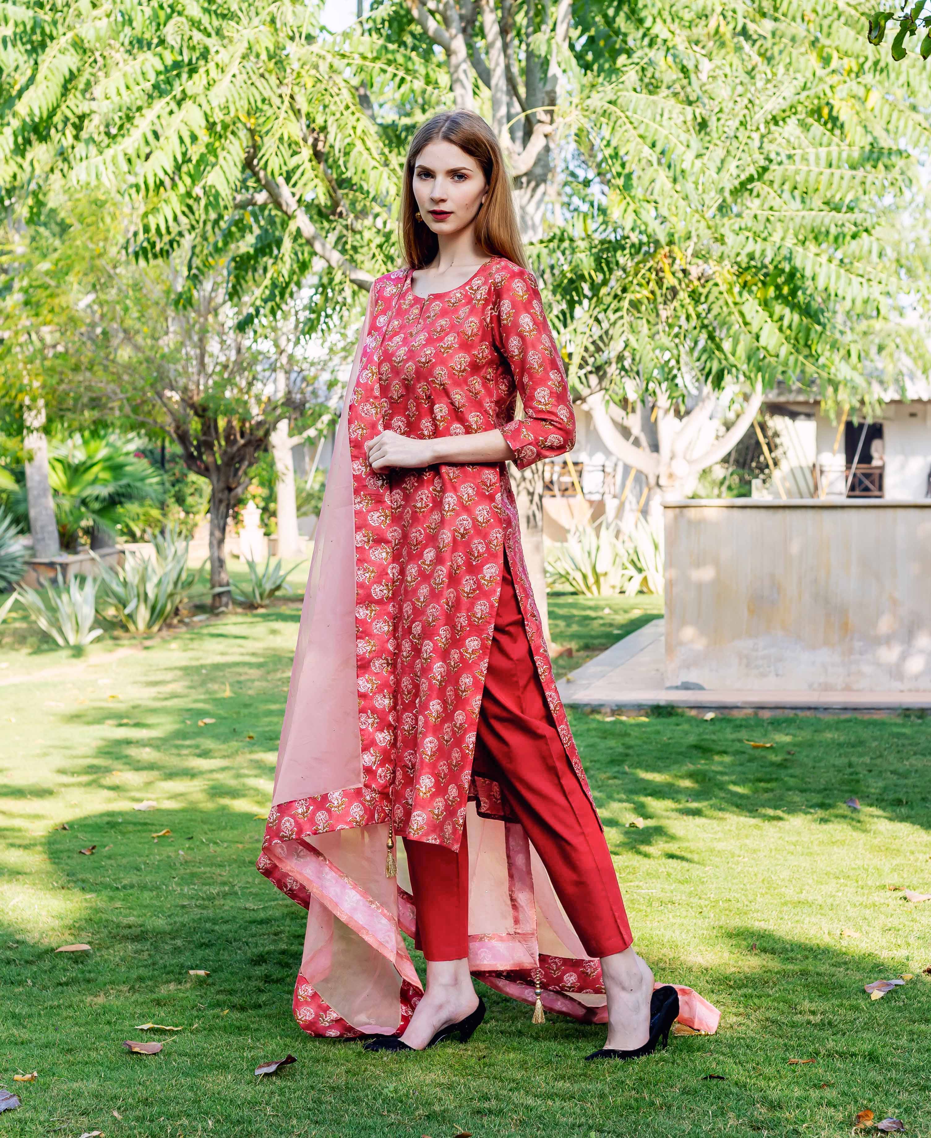 Model in red hand-block printed straight kurta, matching pants, and sheer pink dupatta.