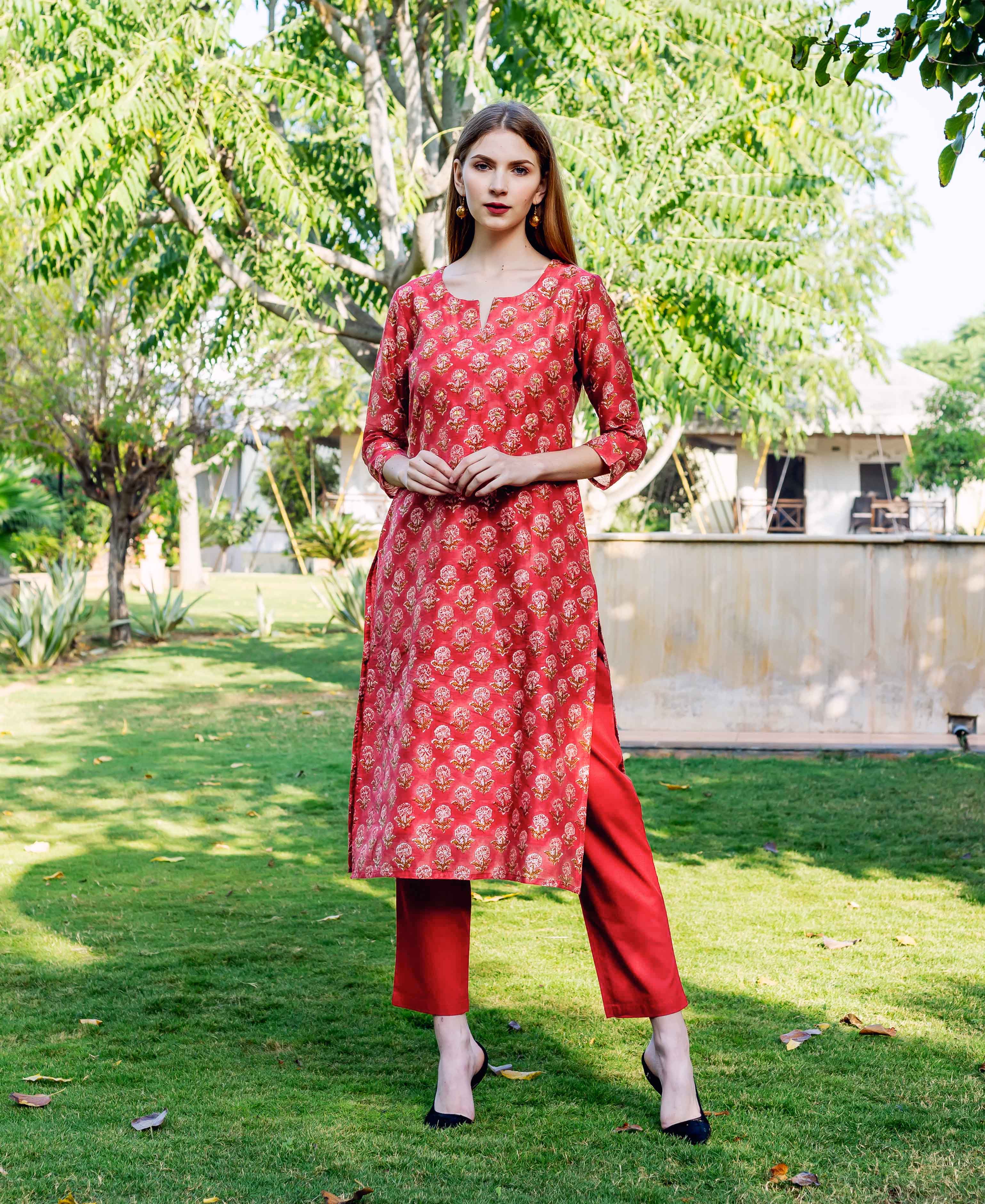 Model wearing a red hand-block printed straight kurta and matching pants with floral motifs.