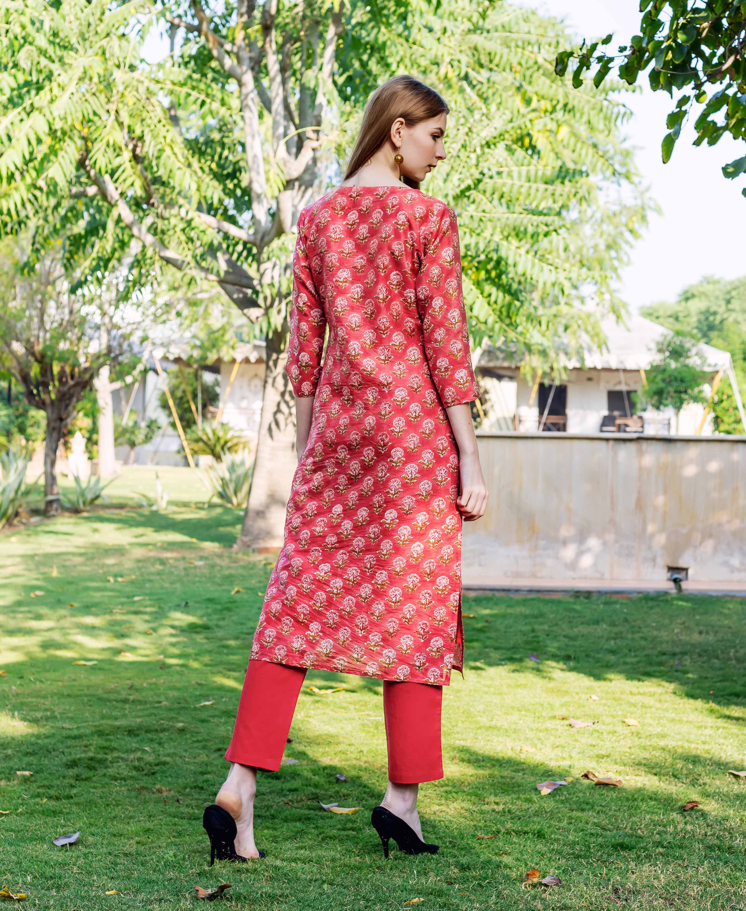 Back view of woman in red hand-block printed straight kurta with ethnic motifs.