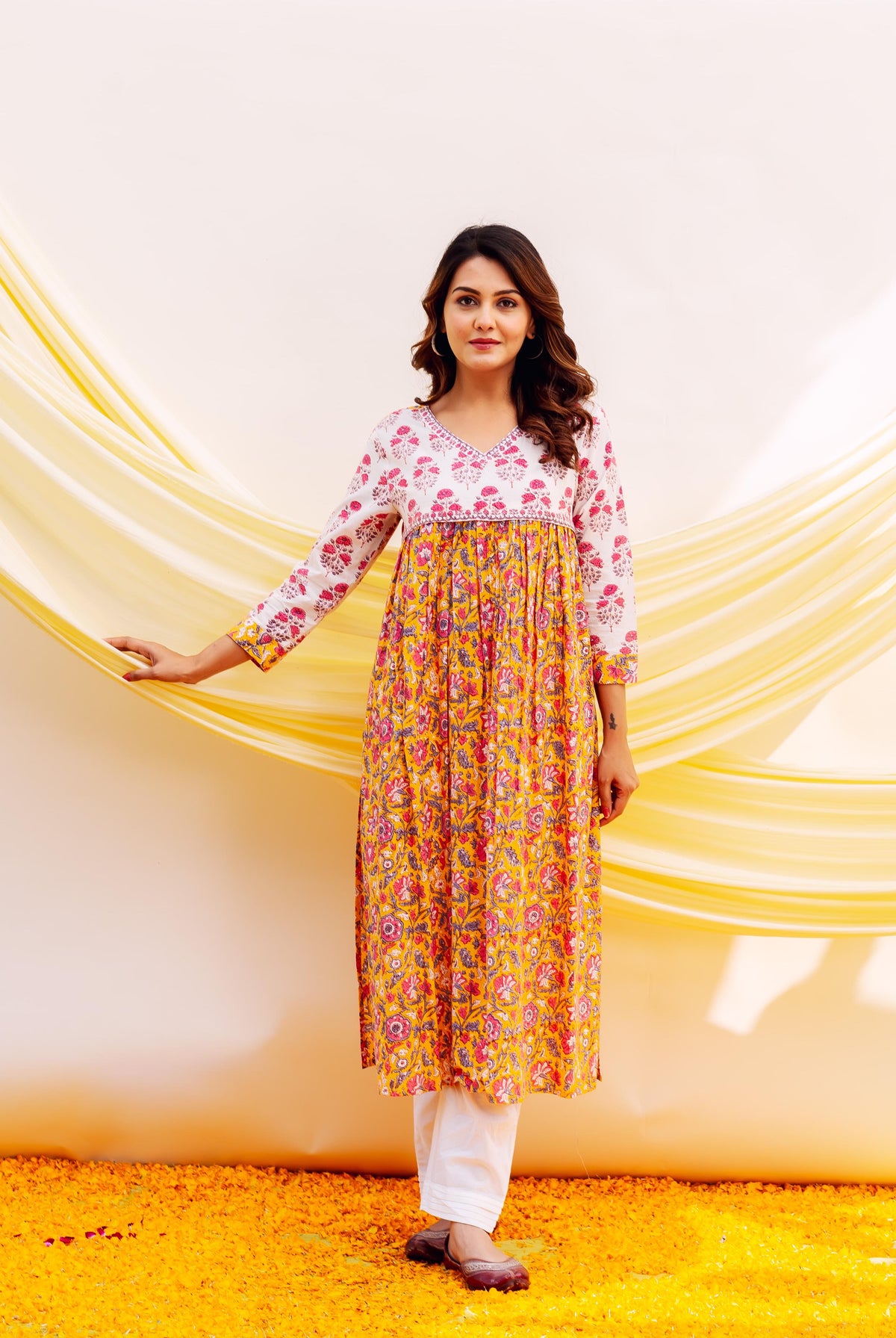 Front view of a model in a white and yellow floral hand-block printed gathered kurta.