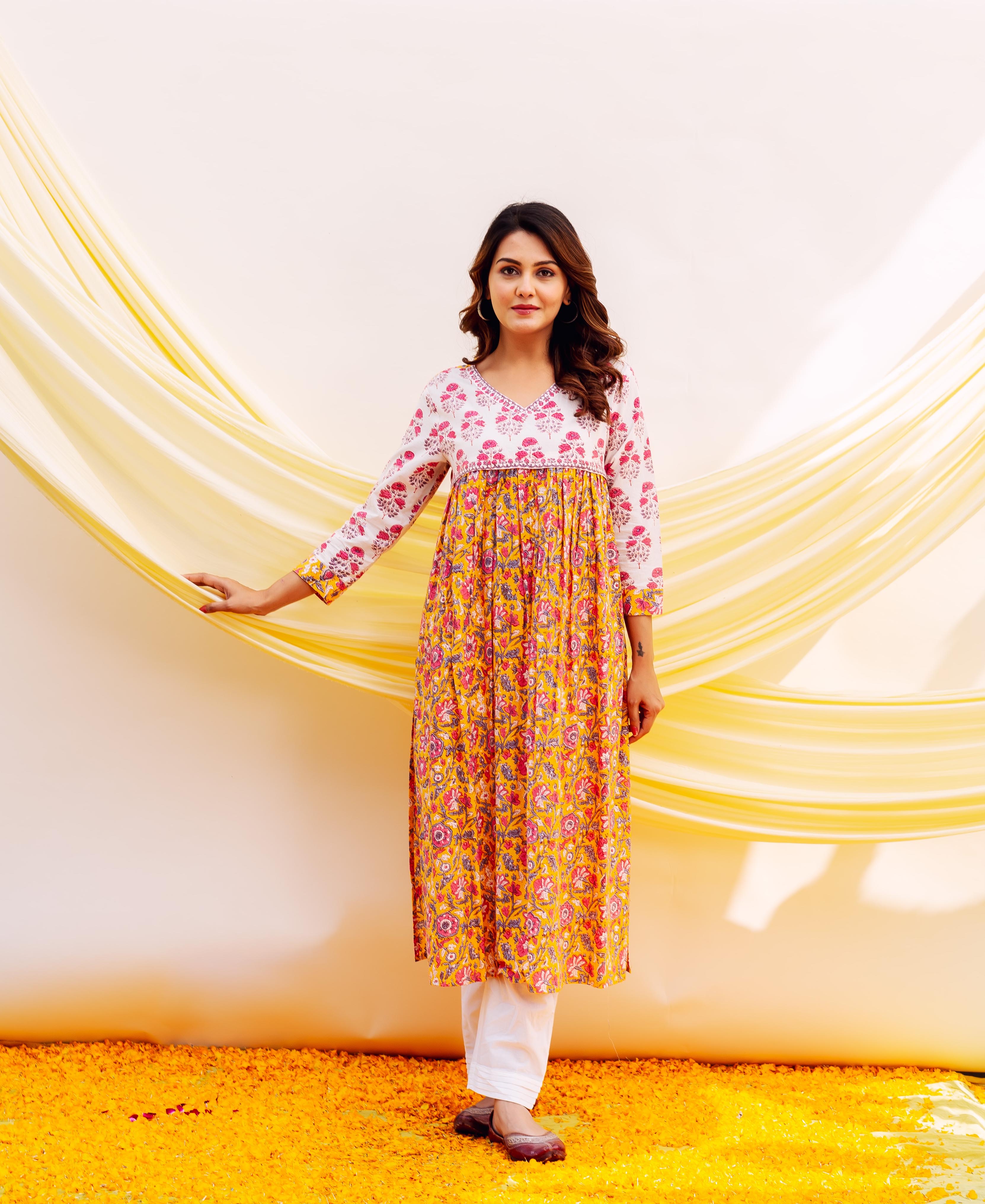 Front view of a model in a white and yellow floral hand-block printed gathered kurta.