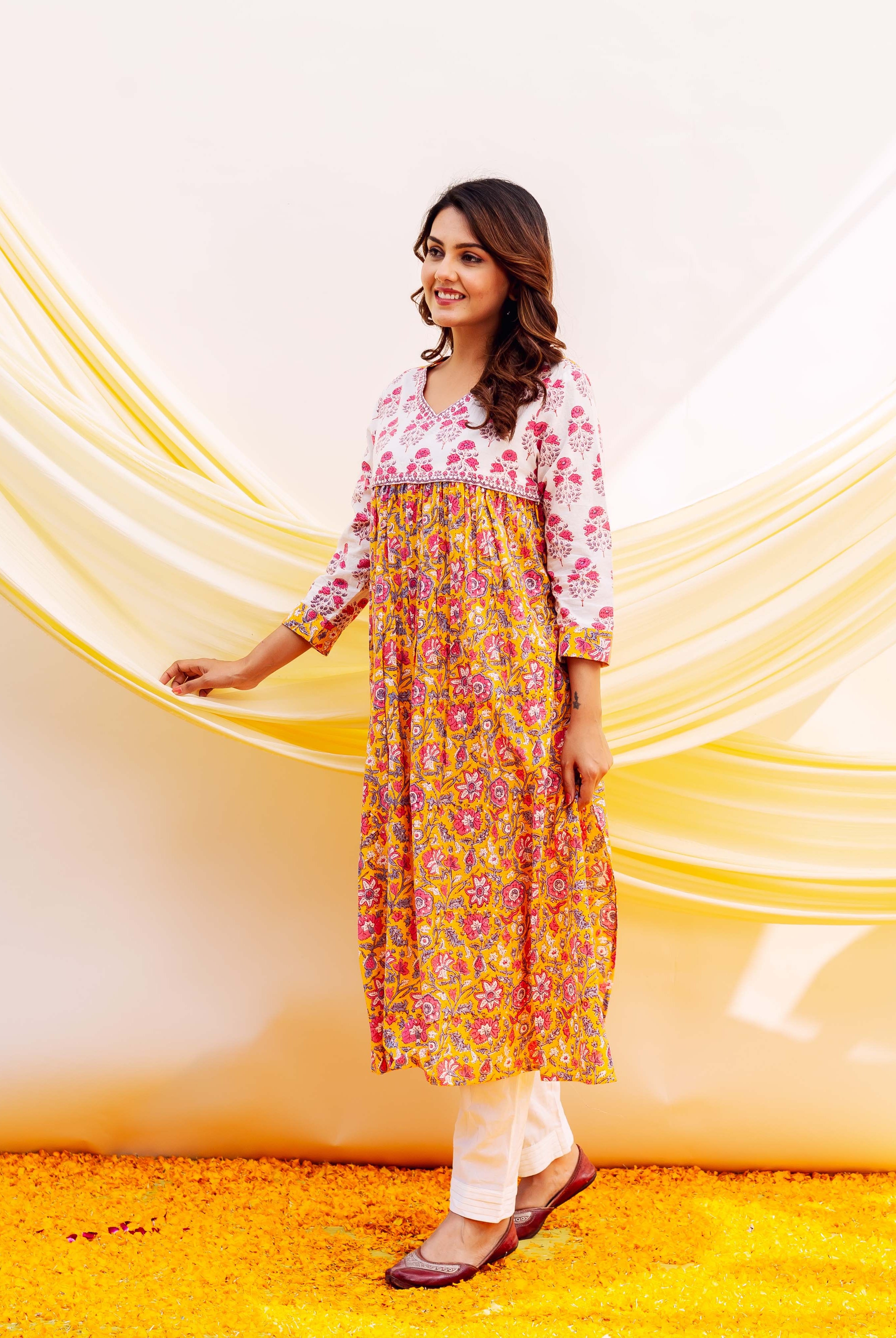Side view of a model in a yellow and white floral hand-block printed kurta.