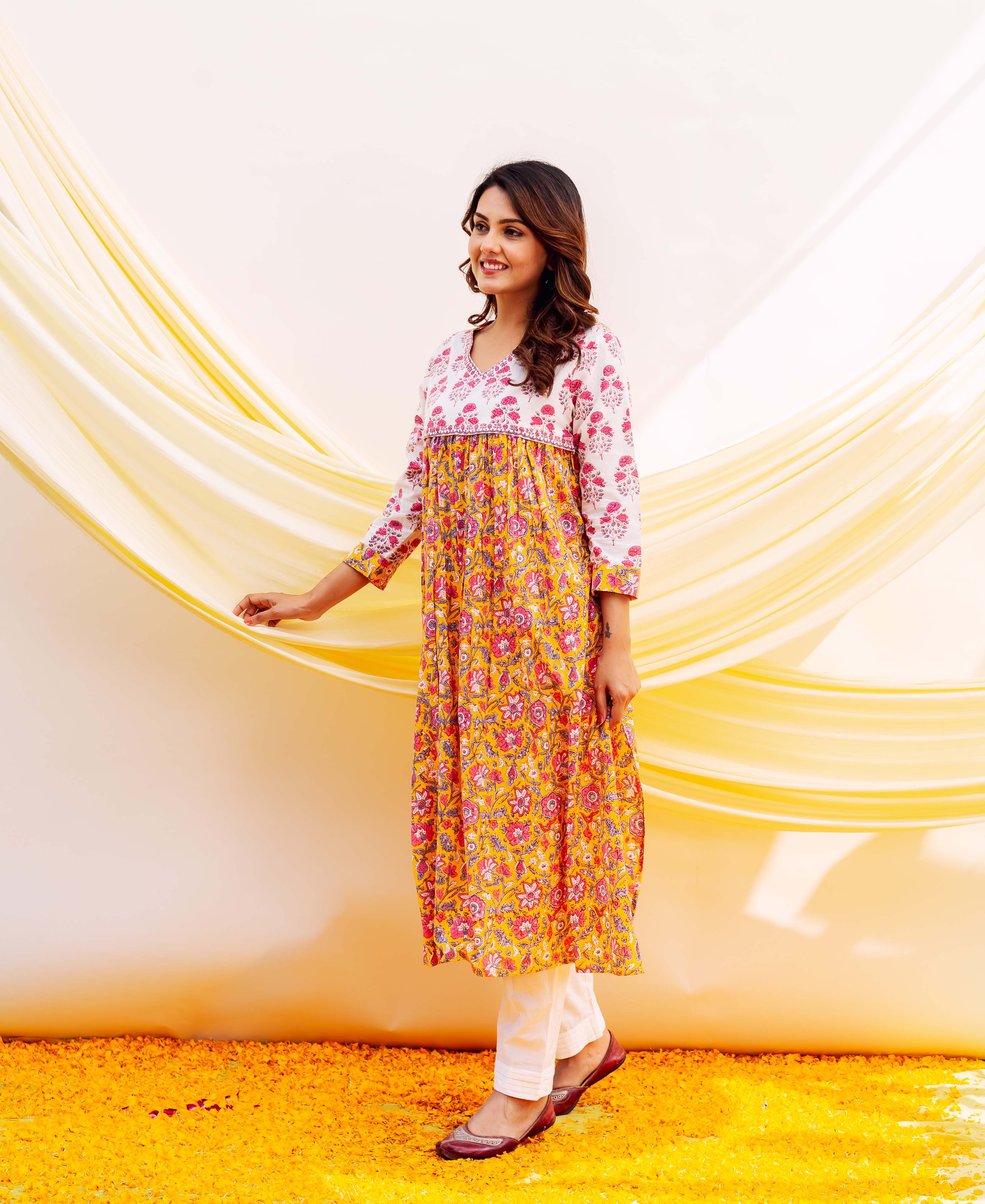 Side view of a model in a yellow and white floral hand-block printed kurta.