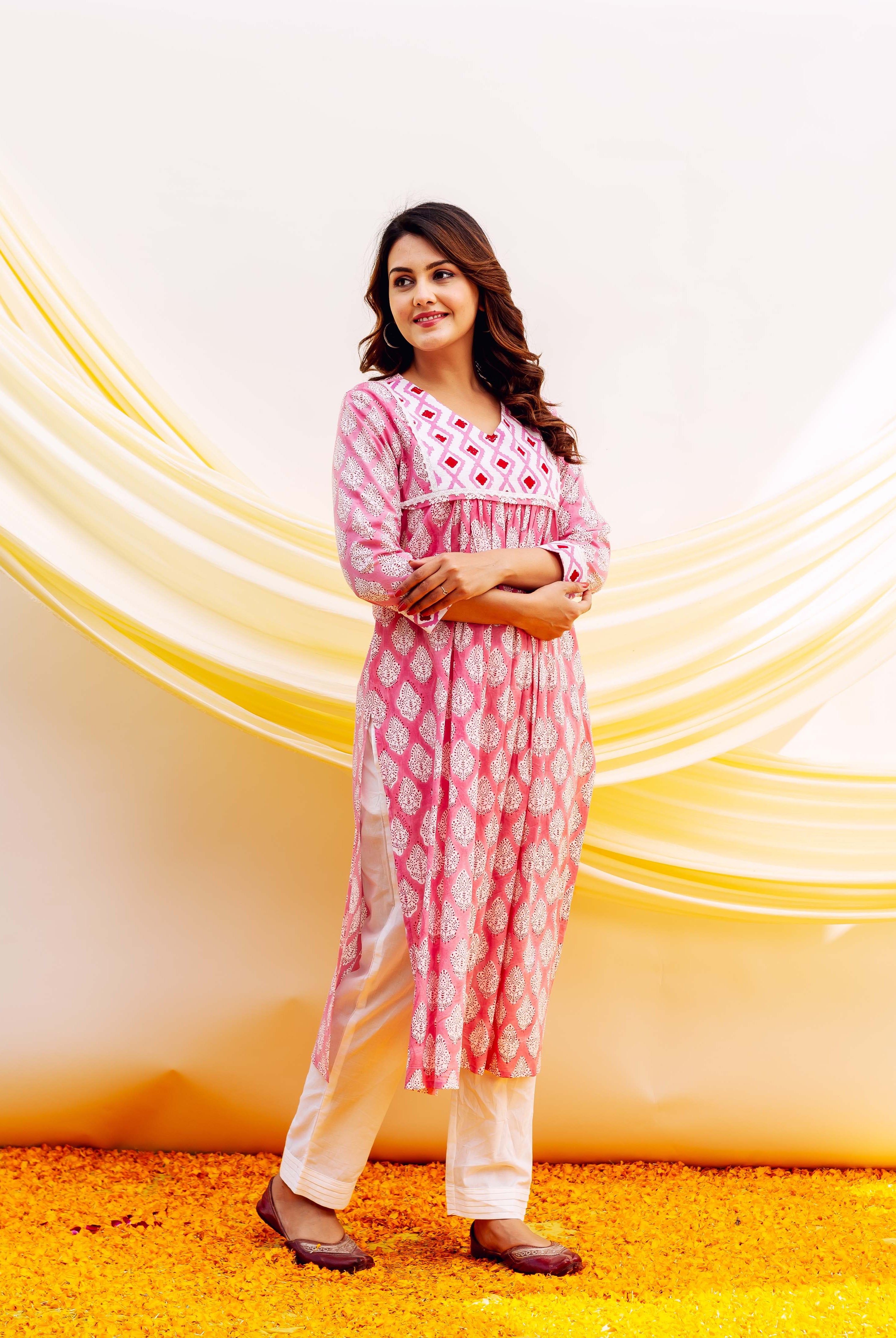 Model in pink block-printed cotton kurta with white leaf motifs, geometric yoke, and white pants.