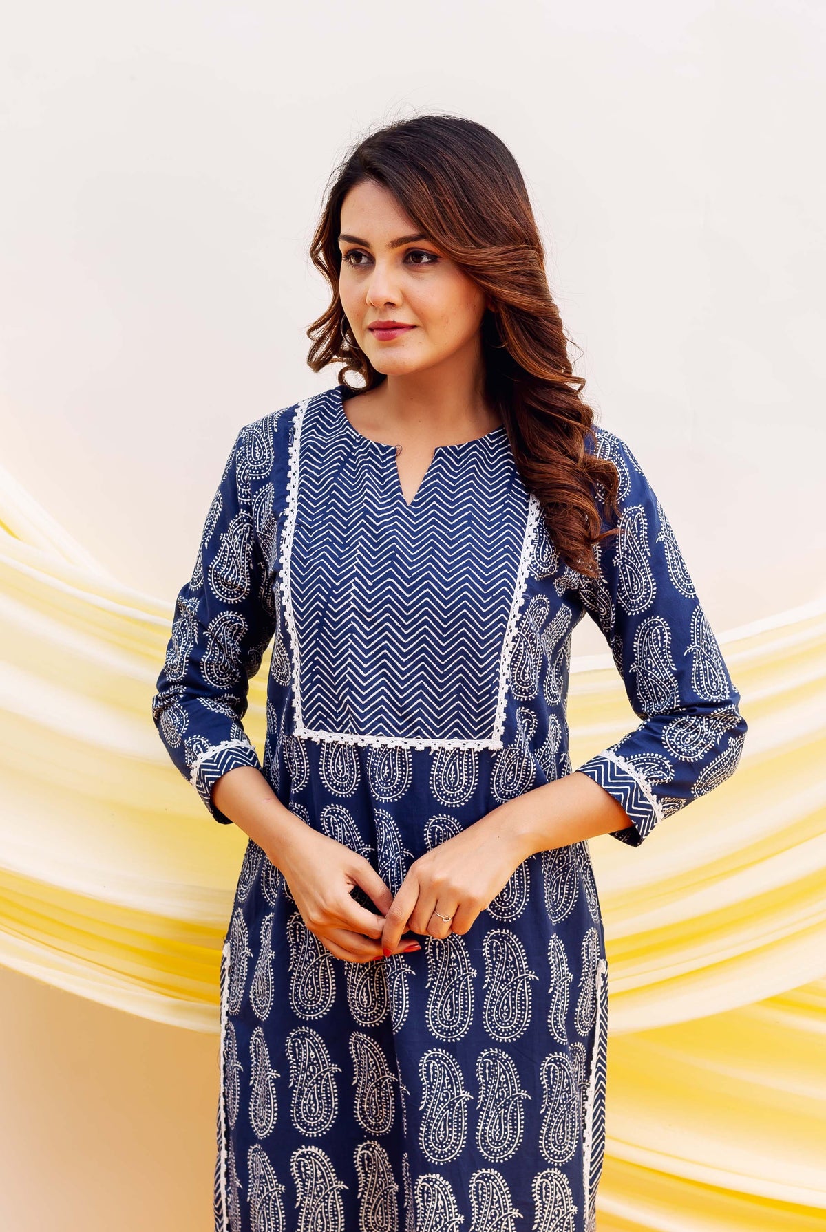Blue and white block printed kurta on model, featuring paisley and chevron patterns.
