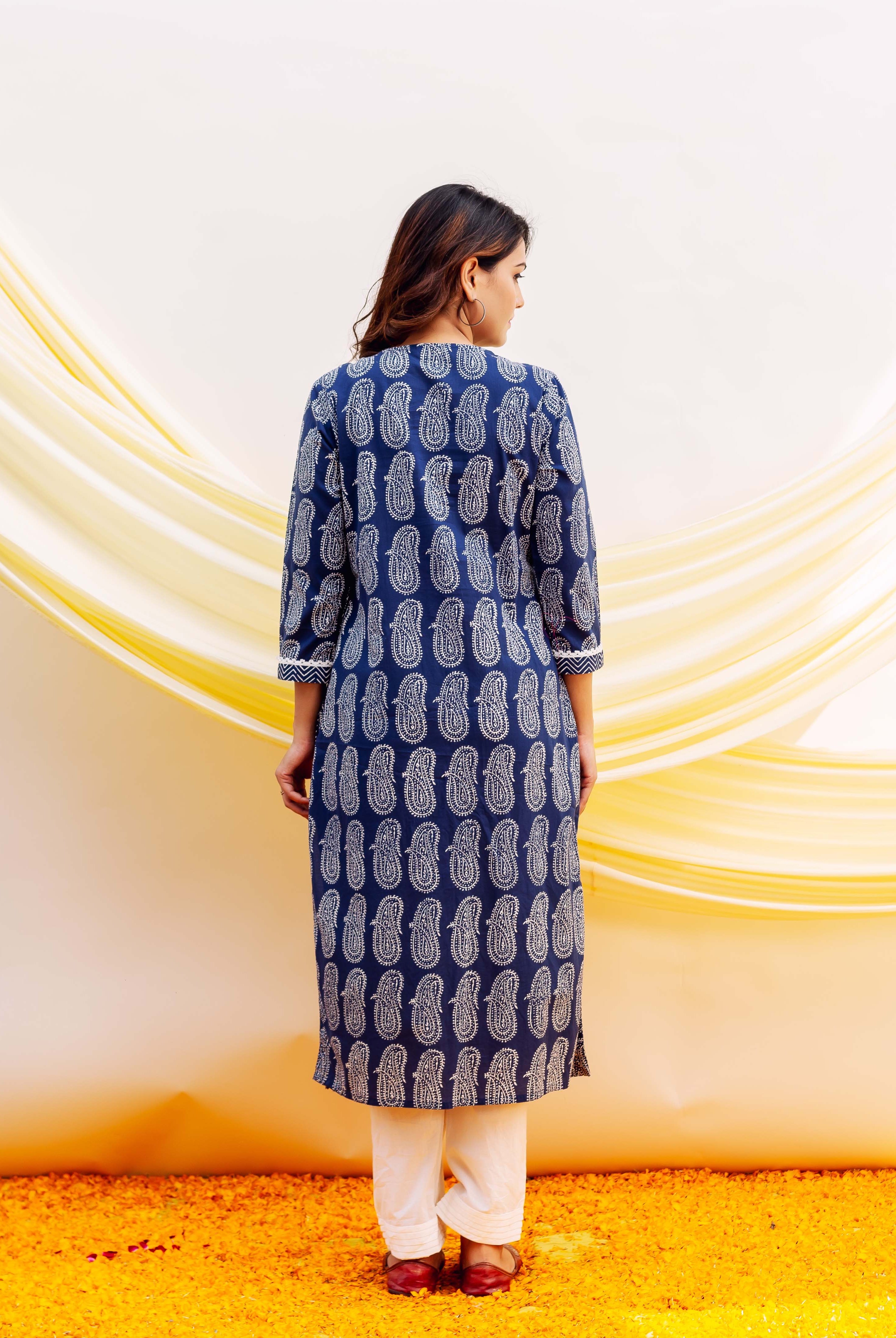 A woman wearing a blue and white block-printed kurta with a paisley pattern.