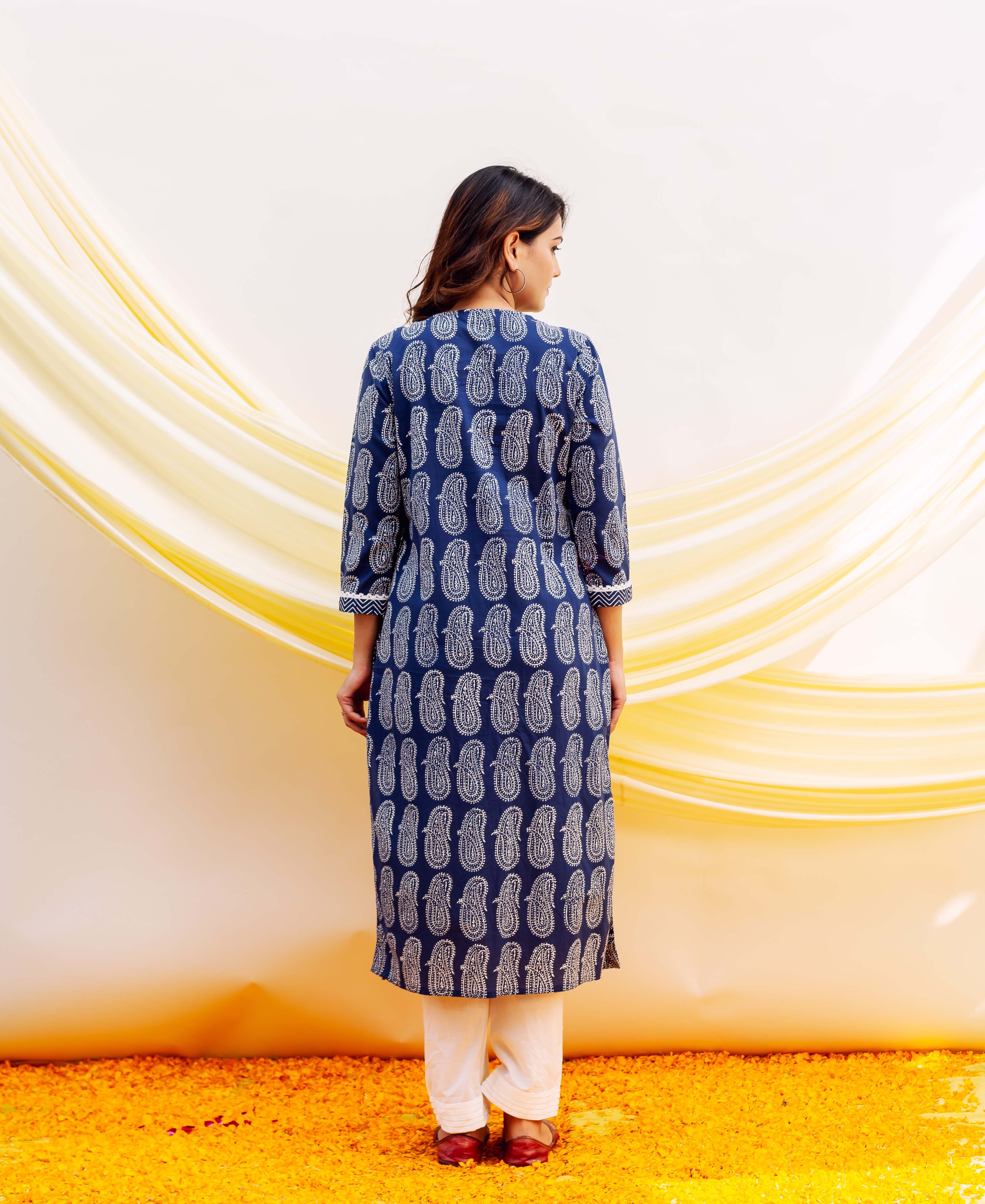 A woman wearing a blue and white block-printed kurta with a paisley pattern.