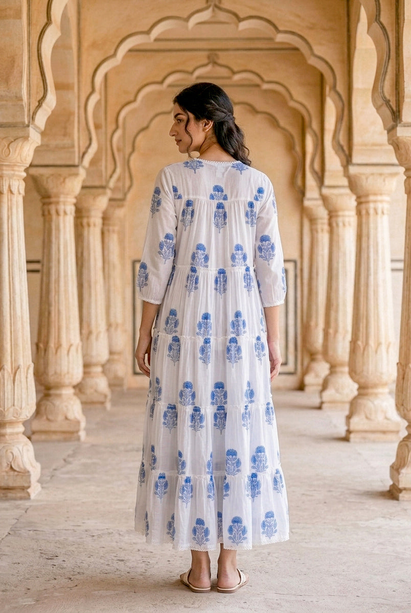Model's back wearing a white, blue floral hand block print tiered maxi dress.