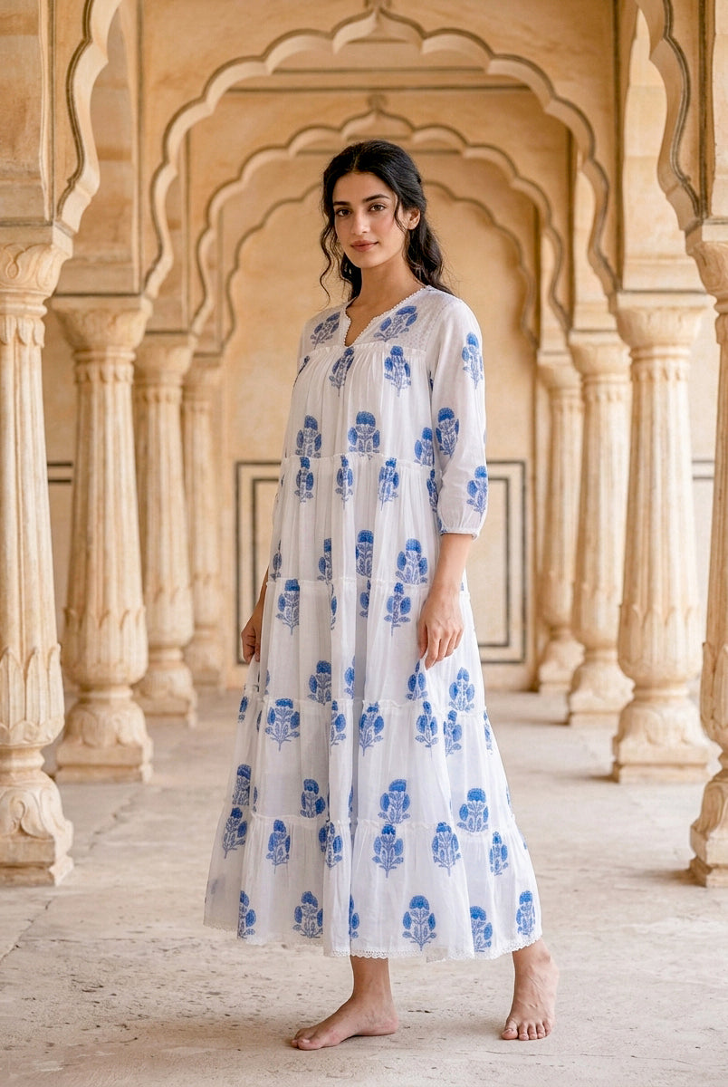 Front full look: model wears white tiered maxi dress with blue floral hand block prints.