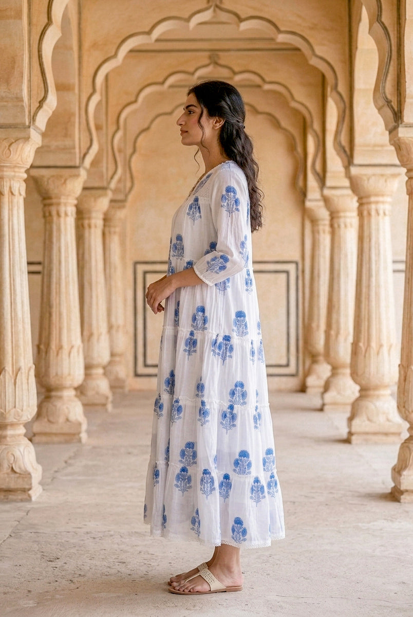 Side view of model wearing white and blue floral hand block print tiered maxi dress.