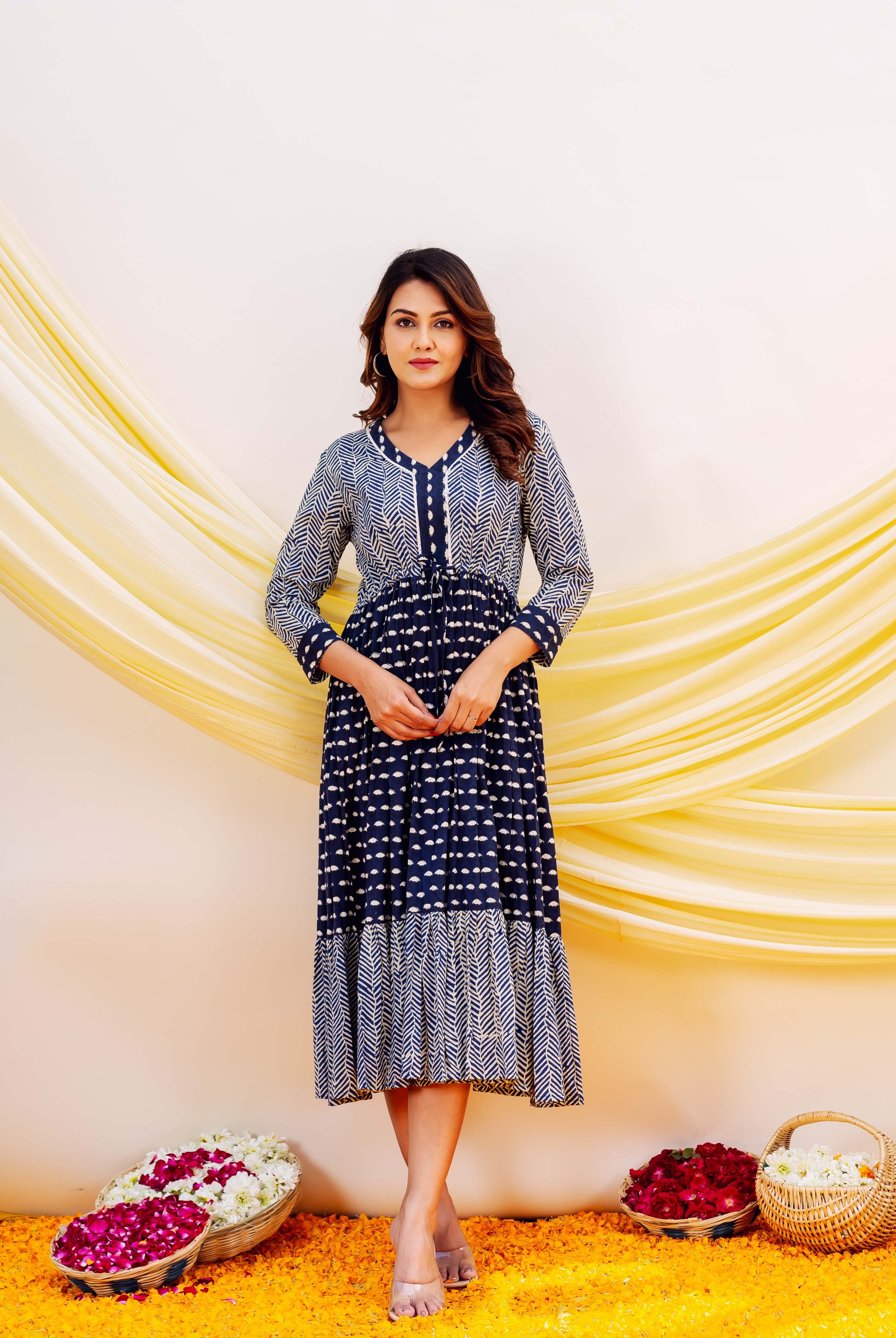 Model wears a full-length indigo blue and white geometric block print dress.