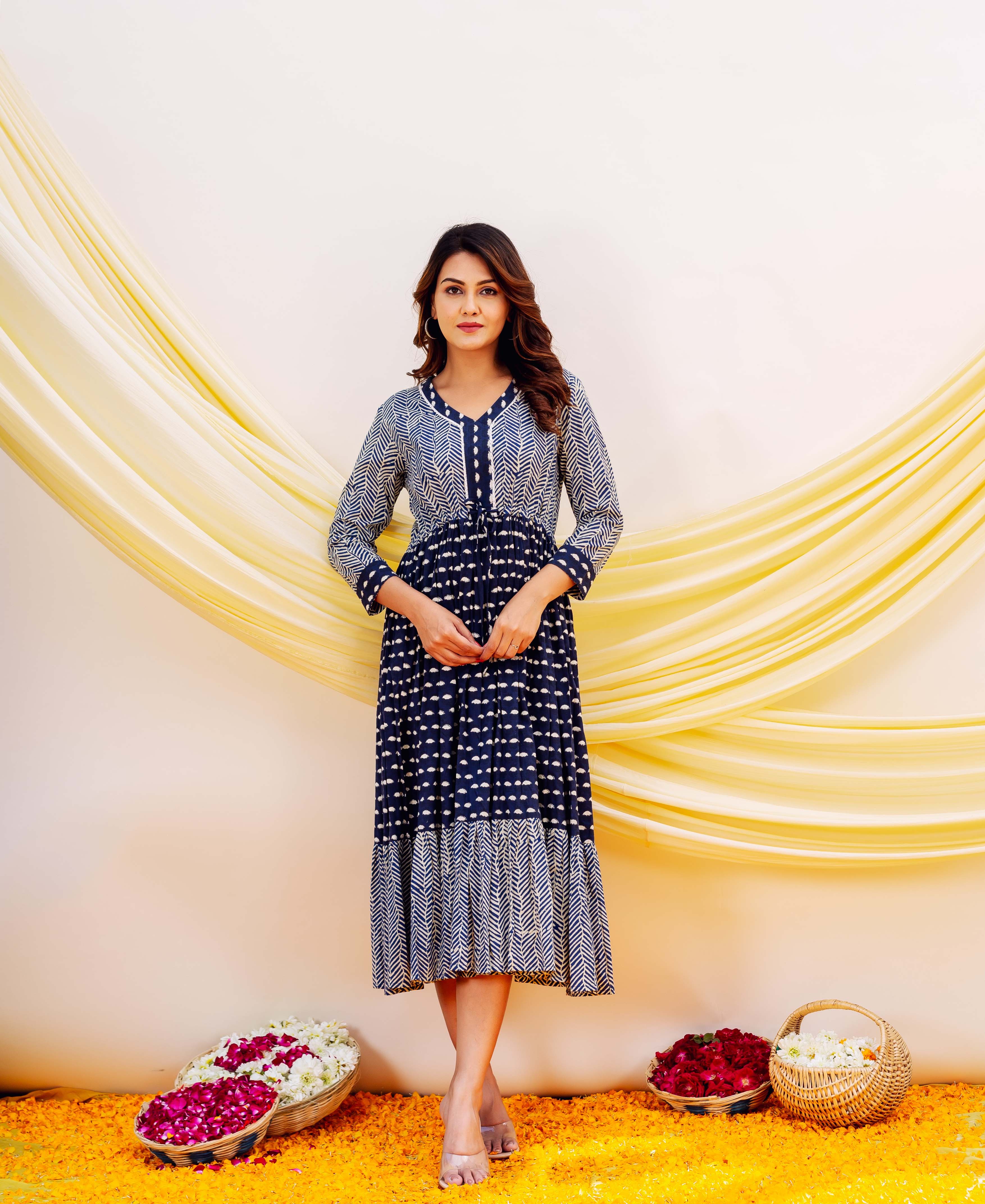 Model wears a full-length indigo blue and white geometric block print dress.