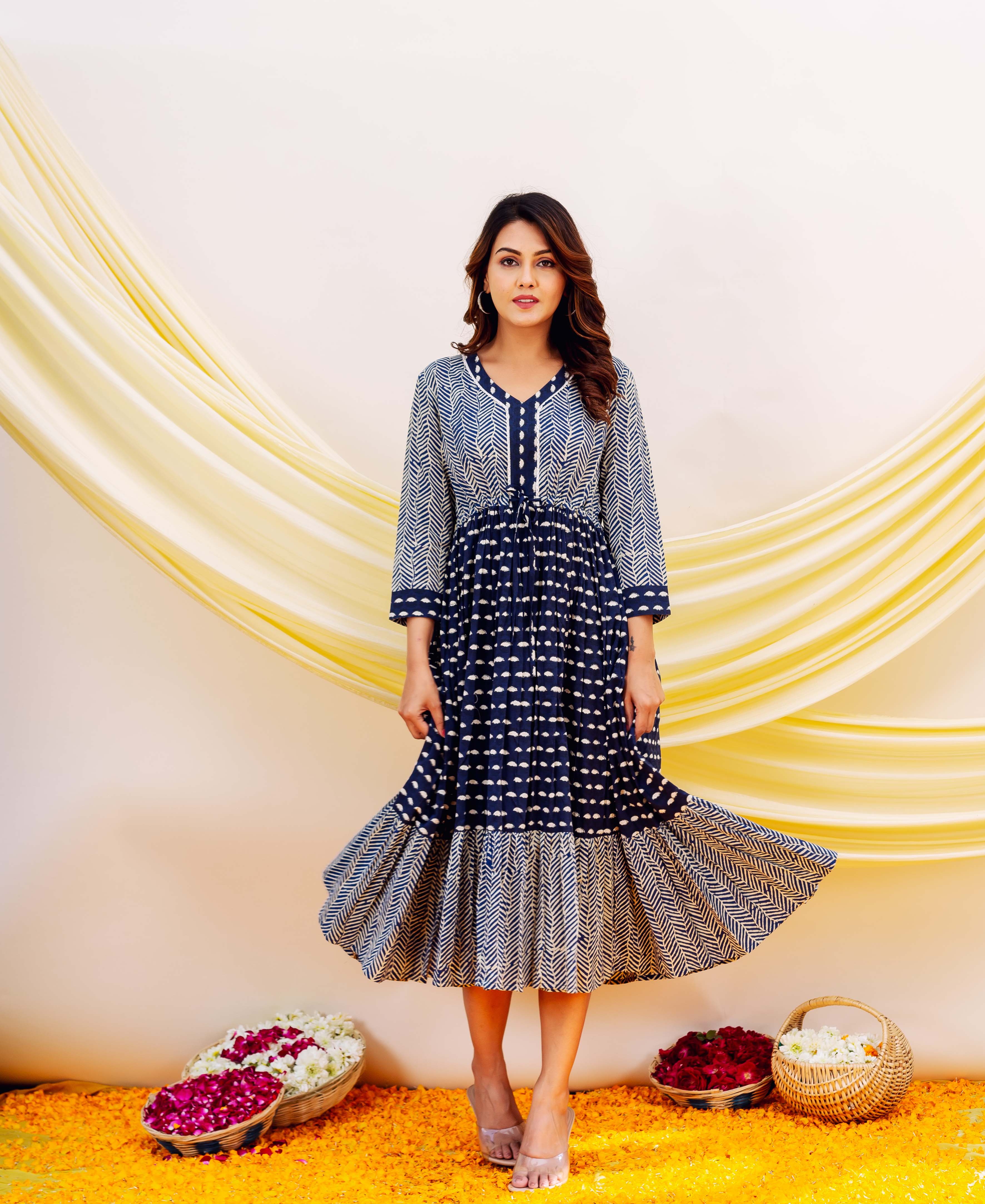 Front view of model in a flowing indigo blue and white block-printed tiered midi dress.