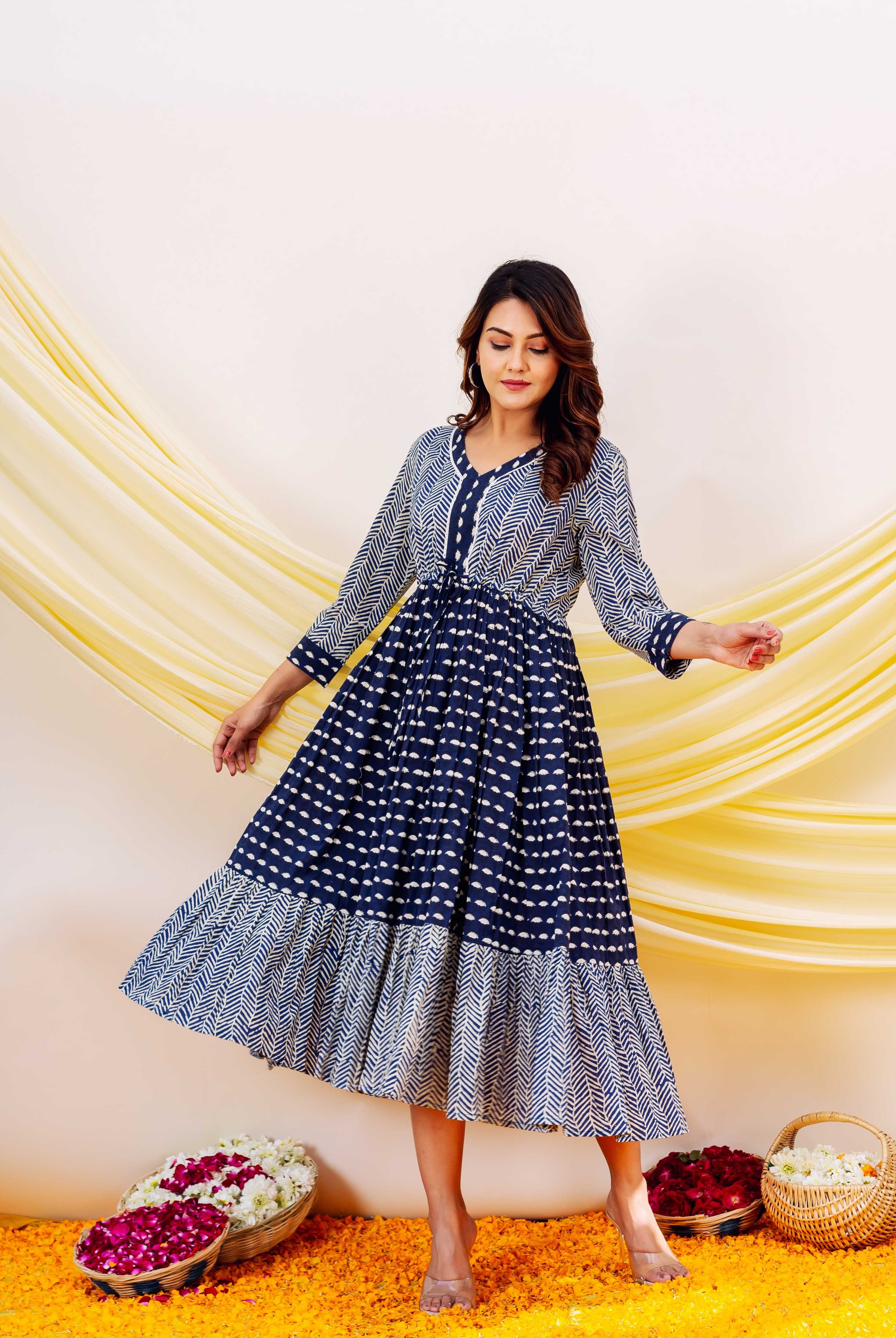 Front full look of model in an indigo and white V-neck block-printed tiered dress.