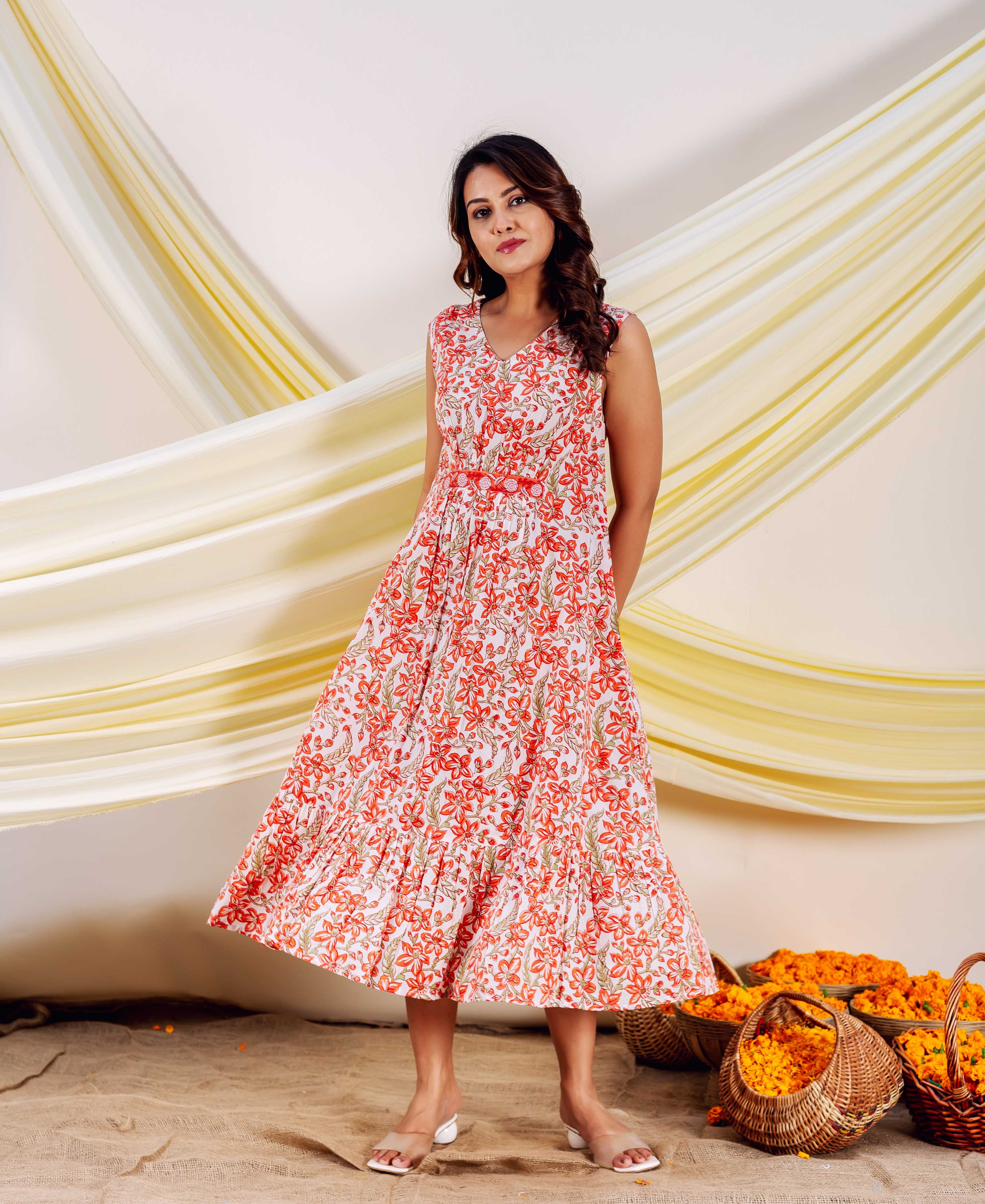 Front full view of model in white sleeveless dress with red floral hand block print.