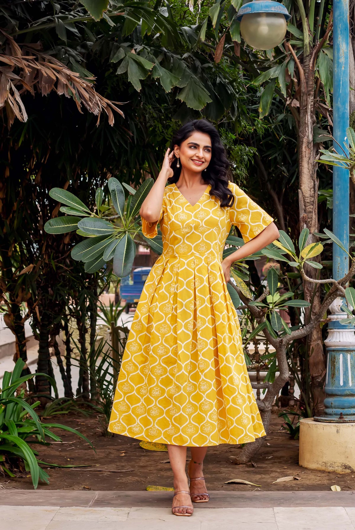 Model in a mustard yellow hand-block-printed midi dress with white ethnic pattern.